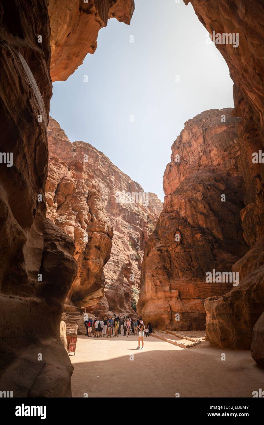 Petra, Giordania - 4 maggio 2022: Persone che passano attraverso il canyon Siq in Petra Ancient Rock Cut City in Giordania. Famoso sito archeologico nel sud della Giordania Foto Stock