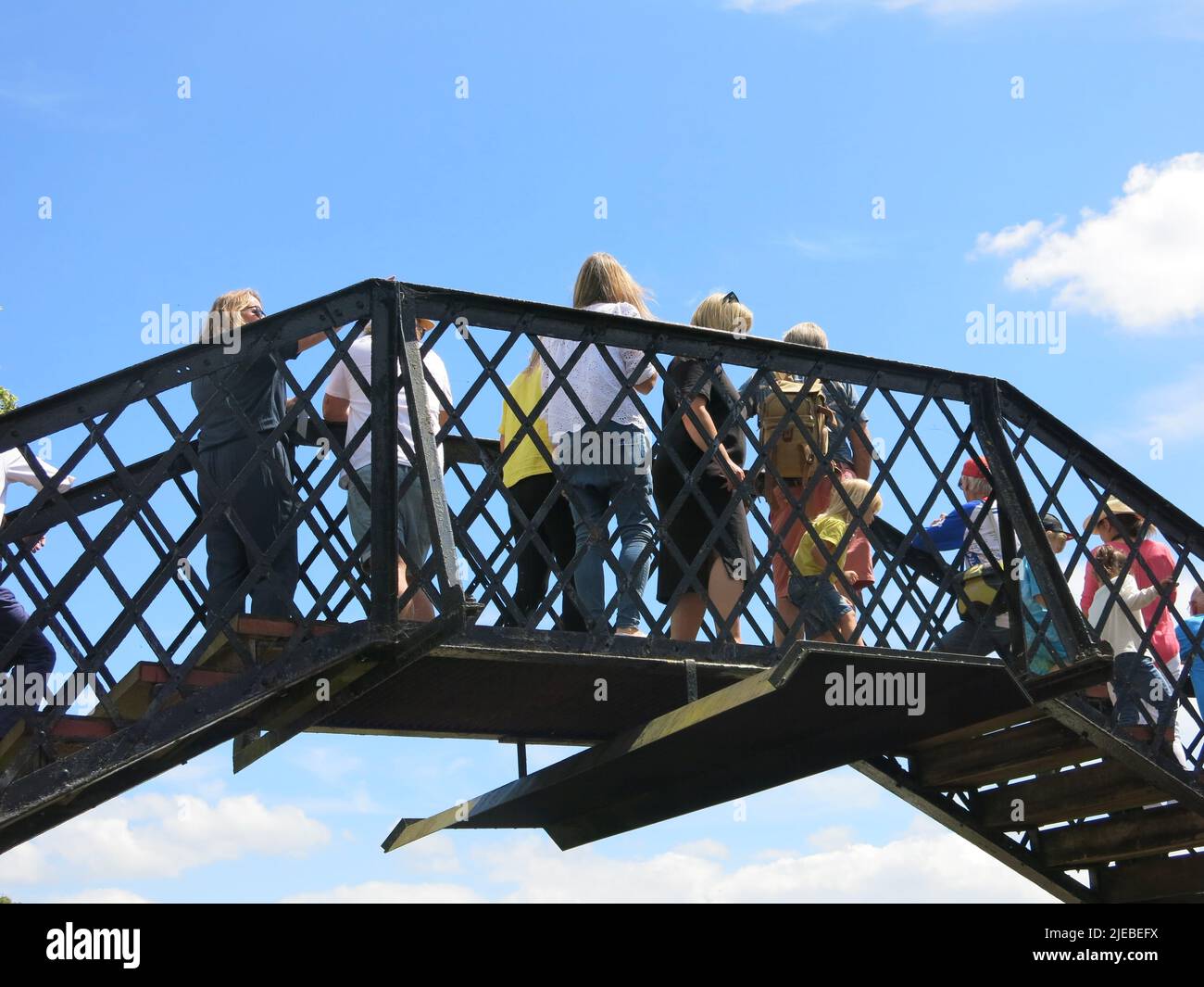 I passeggeri attraversano la passerella pedonale sopra la ferrovia nel terreno di Fawley Hill, la tenuta McAlpine aperta il giorno 2022 giugno Foto Stock