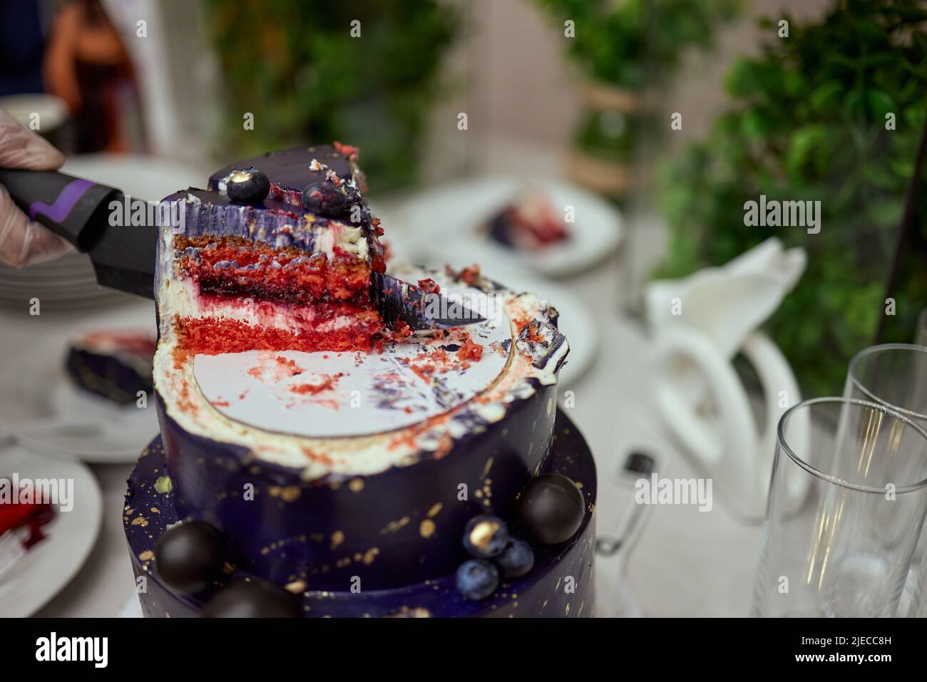 Torta a castello nera su sfondo nero scuro con stelle dorate e sfere decorate sulla parte superiore. Torta di compleanno di lusso Foto Stock