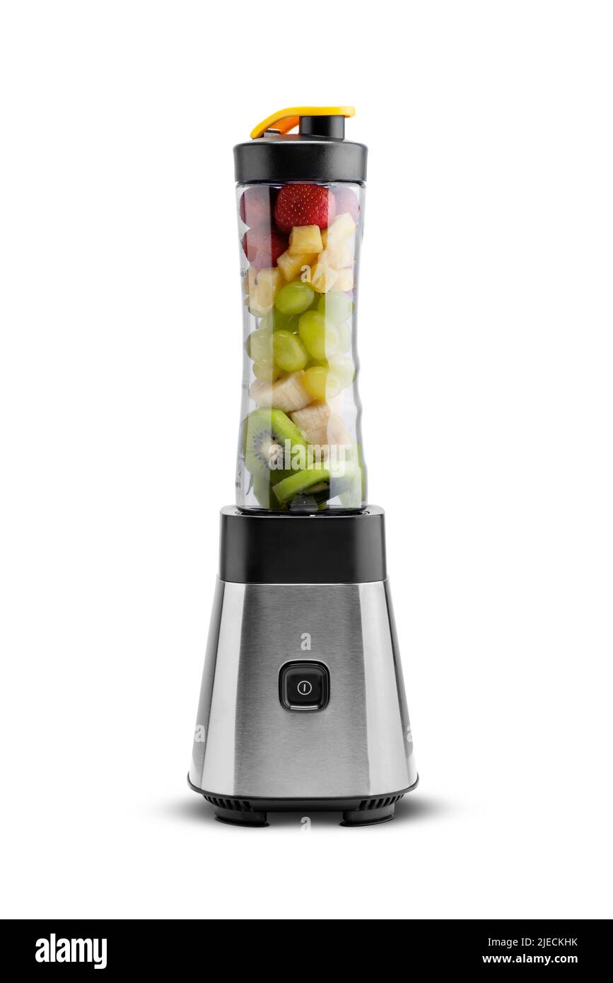 Il frullatore a immersione è pieno di fragole, ananas, banane e kiwi. Foto Stock