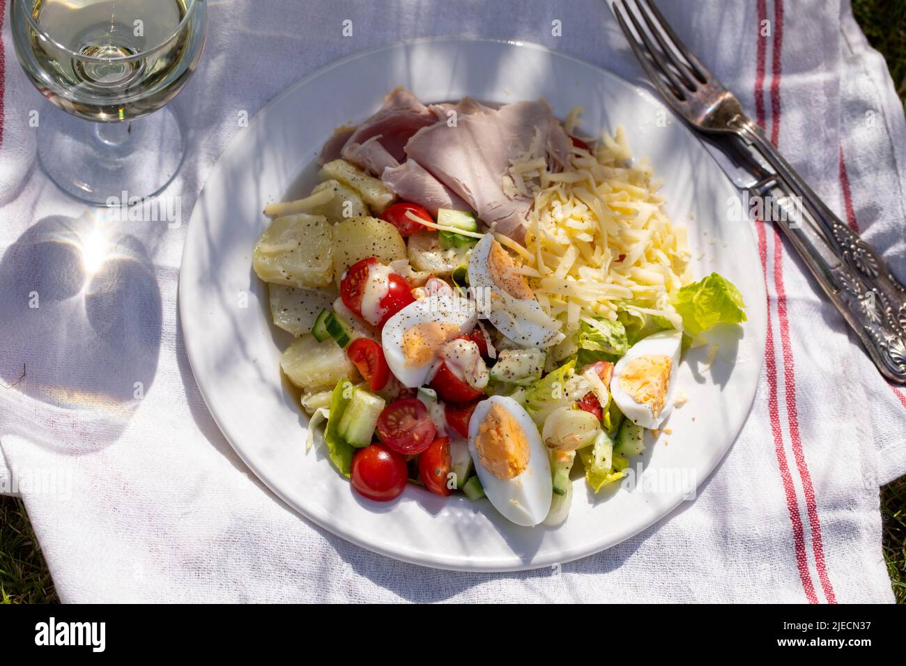 Semplice pasto estivo con patate, insalata, uova, formaggio e prosciutto Foto Stock