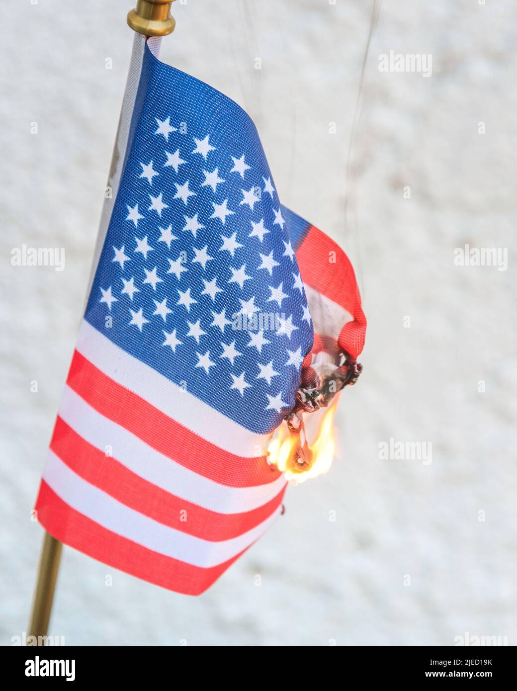 Primo piano di una bandiera americana in fiamme. Foto Stock