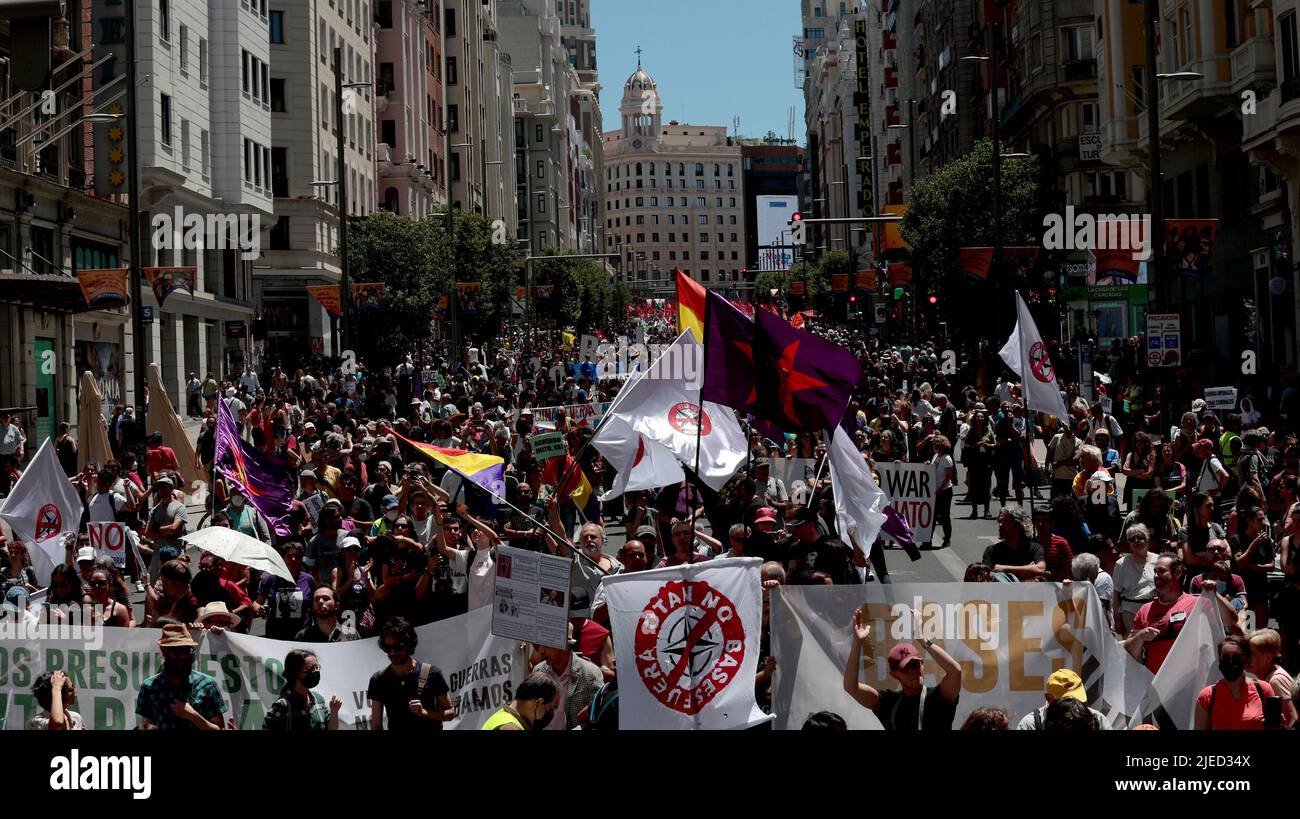 Madrid, Spagna; 26.06.2022.- migliaia di persone protestano a Madrid contro il vertice della NATO che inizia questa settimana nella capitale spagnola. Essi leggono un manifesto unitario, che tra i suoi punti richiede la dissoluzione della NATO, nonché la promozione di un nuovo sistema di sicurezza smilitarizzato, l'invito a rinunciare alla violenza come strumento di risoluzione dei conflitti, il rifiuto di aumentare la spesa militare del 2% del PIL, riconvertire l'intero settore militare e riorientare la spesa per le armi per rafforzare le politiche pubbliche in materia di sanità, istruzione, alloggio, assistenza e parità. Foto: Juan Carlos Rojas Foto Stock