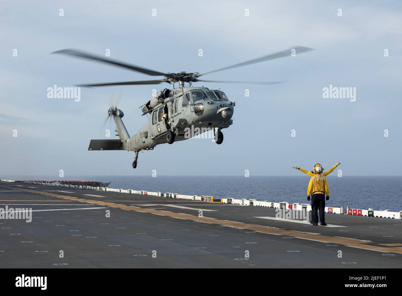 Un elicottero marino della marina statunitense MH-60s Sea Hawk con elicottero Sea Combat Squadron (HSC) 23 solleva il vettore d'assalto anfibio USS Tripoli (LHA 7), mentre era in corso, il 11 giugno 2022. Il vettore d'assalto anfibio USS Tripoli (LHA 7) sta conducendo operazioni di routine all'interno della flotta USA 7th. (STATI UNITI Foto del corpo marino di Sgt. Jackson Ricker) Foto Stock