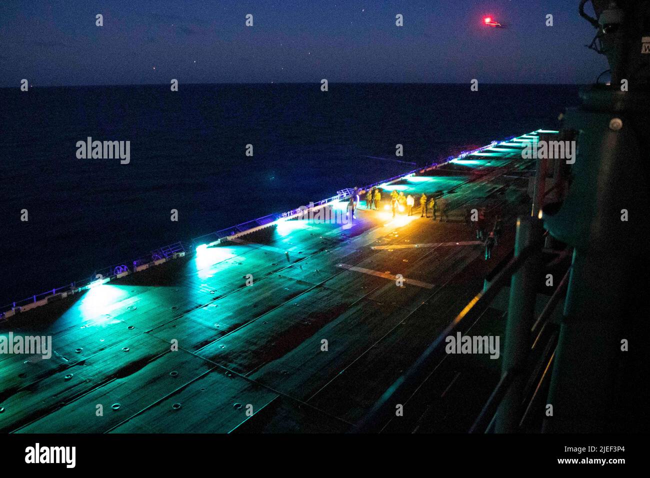 220624-N-XN177-2336 OCEANO PACIFICO (24 giugno 2022) – marinai e marines conducono una discesa di detriti di oggetti estranei (FOD) durante le operazioni di volo notturno a bordo di un vettore di assalto anfibio USS Tripoli (LHA 7), 24 giugno 2022. Tripoli opera nell'area operativa della flotta USA 7th per migliorare l'interoperabilità con alleati e partner e servire come forza di risposta pronta a difendere la pace e mantenere la stabilità nella regione Indo-Pacific. (STATI UNITI Foto Navy di Mass Communication Specialist 1st Classe Peter Burghart) Foto Stock