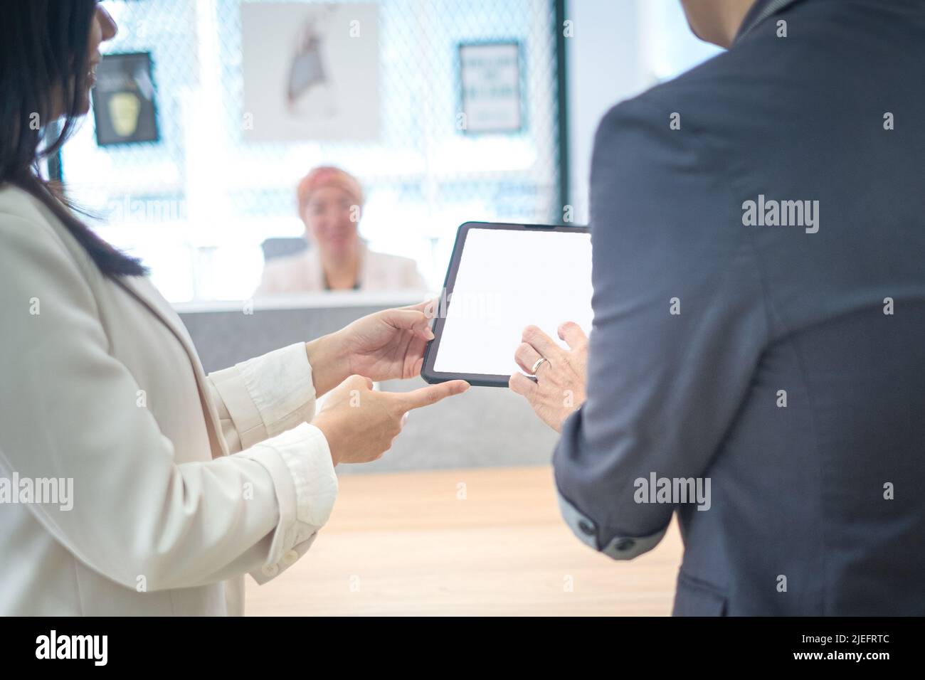 Un collega aziendale che mostra qualcosa sul tablet digitale a un altro collega. Impostazione Office. Foto Stock