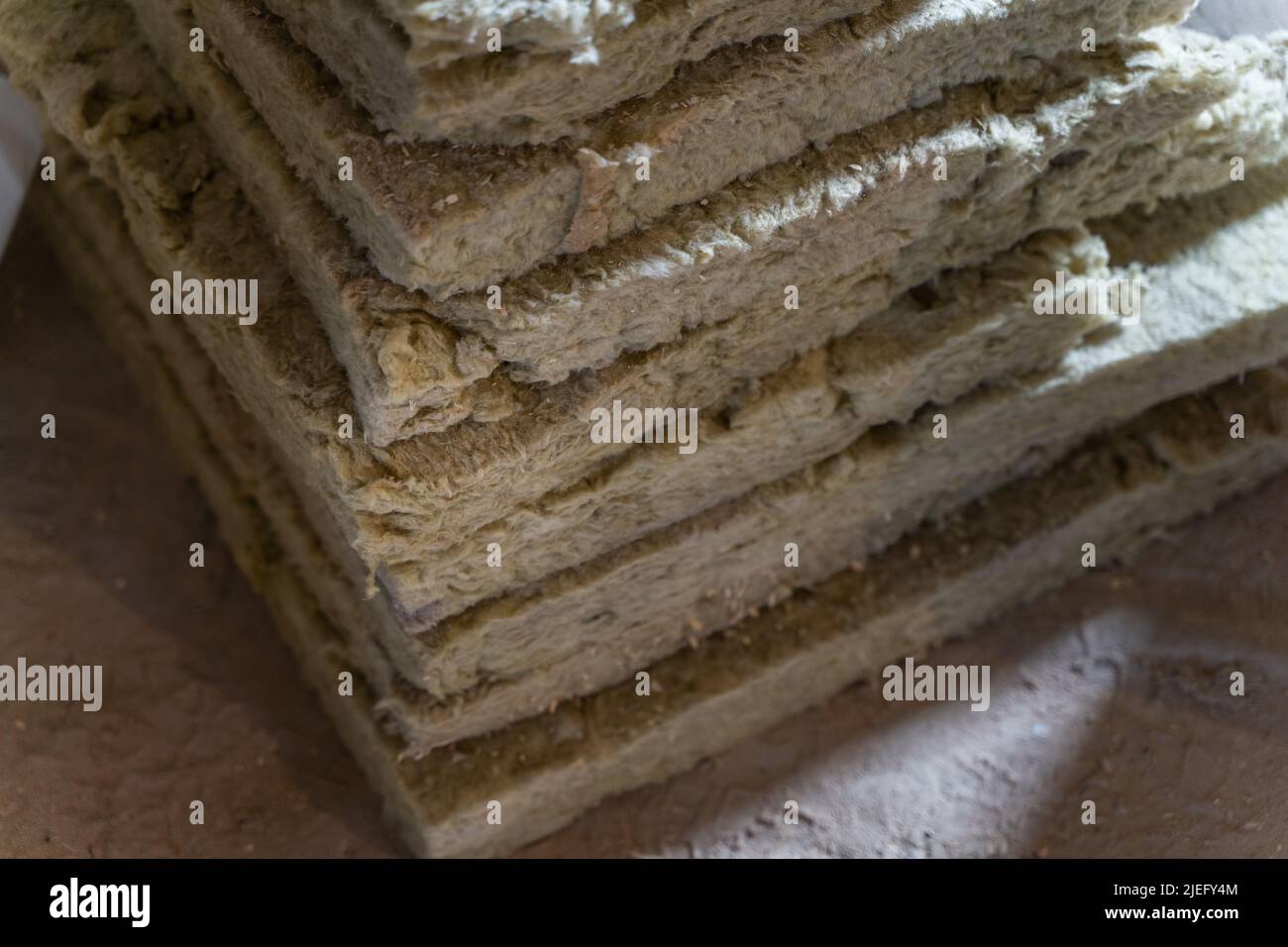 Scarti di lana minerale verde accumulati. Materiale di isolamento sicuro per la casa Foto Stock