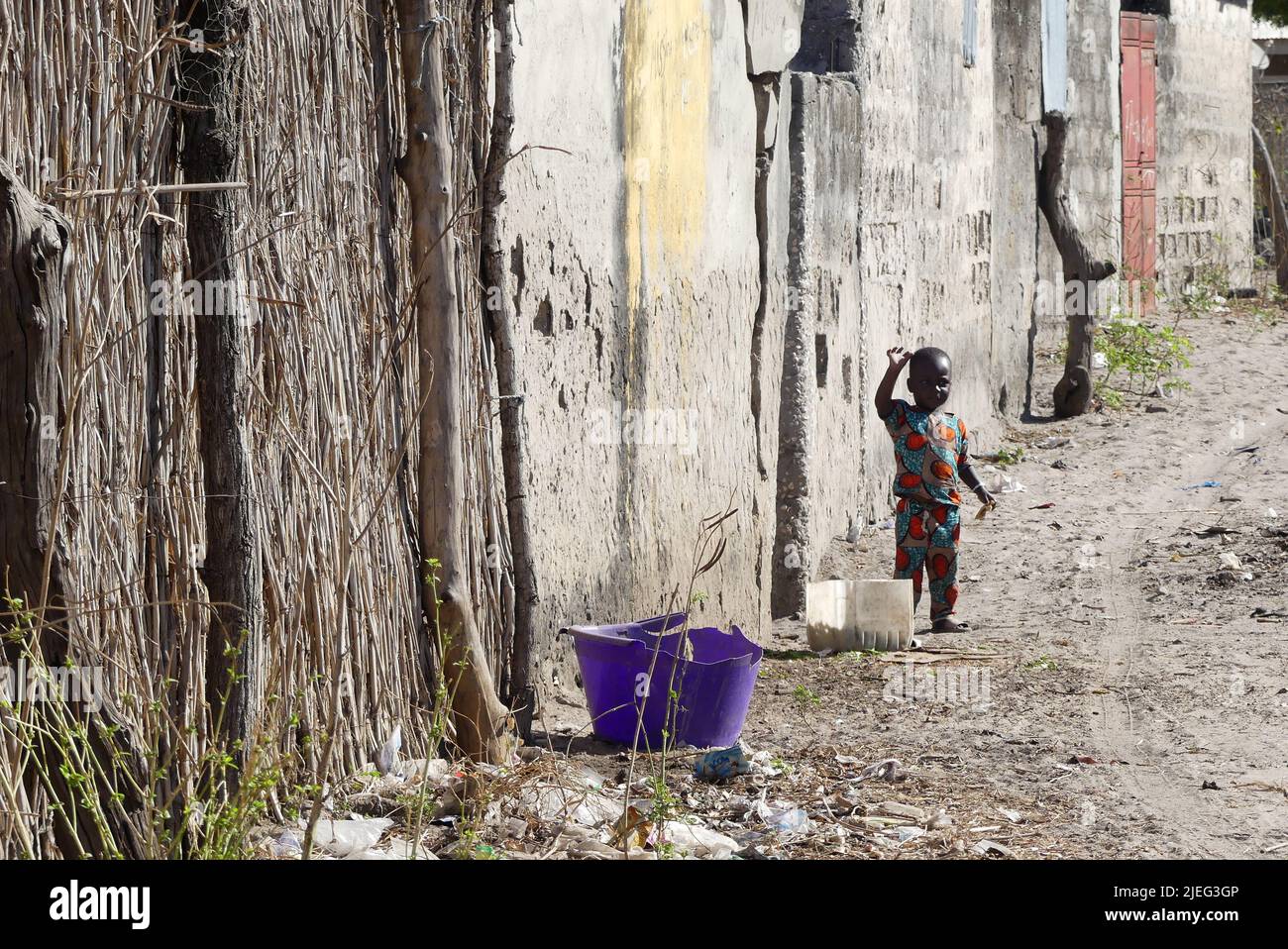 Giovane bambino nero africano, di colore nero, in un quartiere povero di Touba città, Senegal, Africa occidentale Foto Stock