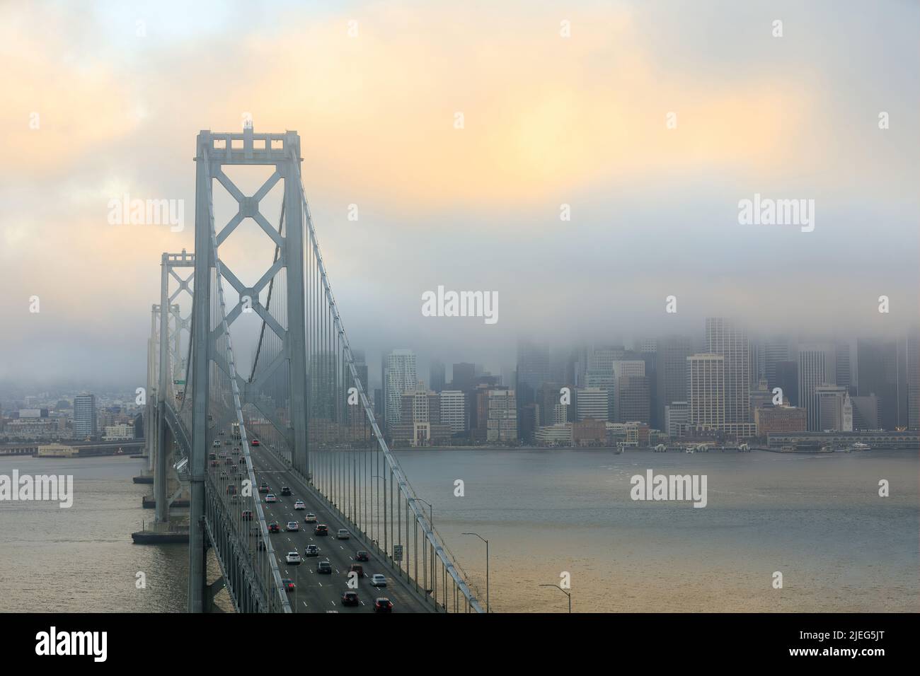 Tramonto con nebbia sul San Francisco Bay Bridge e sul lungomare attraverso l'isola di Yerba Buena. Foto Stock