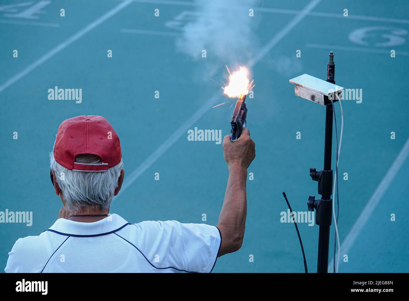 Pistola di avviamento in corso di cottura. Mano che spara una pistola per iniziare la corsa. Milano, Italia - Giugno 2022 Foto Stock