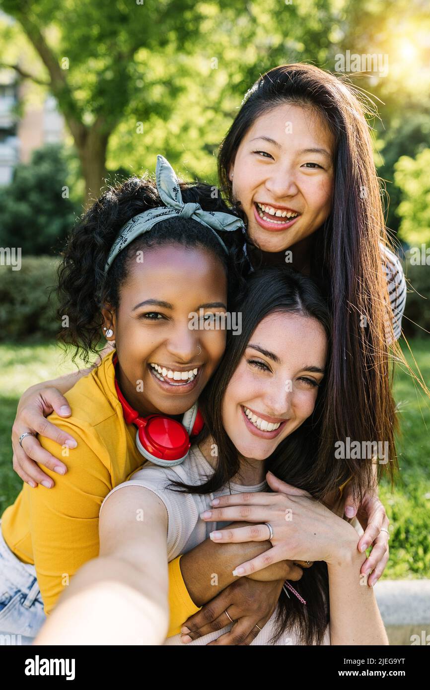 Diverse giovani donne che prendono selfie insieme al telefono cellulare all'aperto Foto Stock