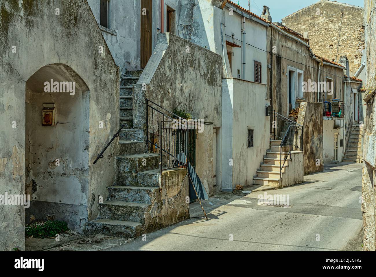 Caratteristico vicolo con scalini che conducono alle case di un borgo pugliese mediterraneo. Vico del Gargano, provincia di Foggia, Puglia, Italia, Europa Foto Stock