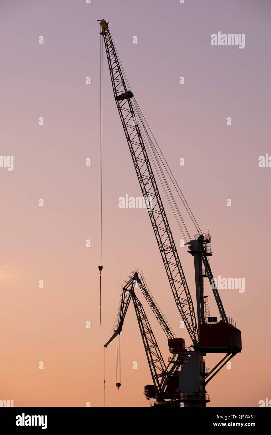 Helsinki / Finlandia - 26 GIUGNO 2022: Una silhouette di una vecchia gru da cantiere contro il tramonto Foto Stock