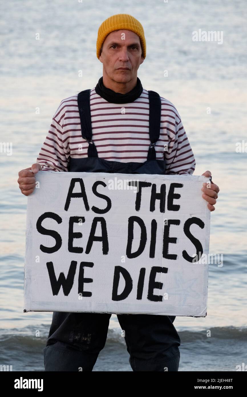 Lisbona, Portogallo. 27th GIU 2022. I membri della Ocean Rebellion eseguono un'azione teatrale creativa in cui Dead Merfolk viene lavato all'alba, catturato in una rete da traino insieme ai detriti del mare (sia plastica che cigolone). La ribellione oceanica chiede alle Nazioni Unite di porre fine a tutti i sussidi nazionali per il carburante alle flotte pescherecce e di bandire la pesca a strascico sulla base sia della perdita inutile di biodiversità, attraverso le catture accessorie, sia del rilascio di carbonio blu. Credit: Dan Pearson/Alamy Live News Foto Stock