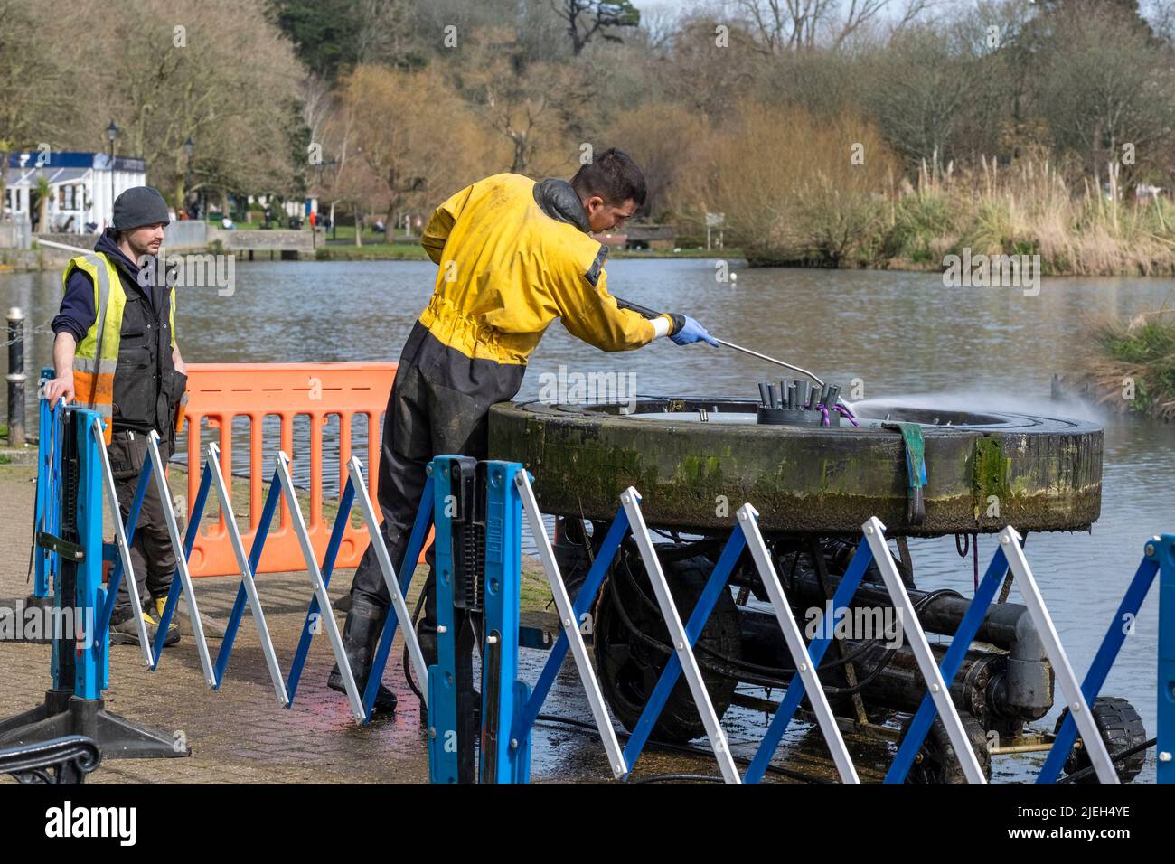 Un lavoratore che utilizza una idropulitrice che esegue lavori di manutenzione su una fontana al lago di canottaggio di Trenance a Newquay in Cornovaglia nel Regno Unito. Foto Stock