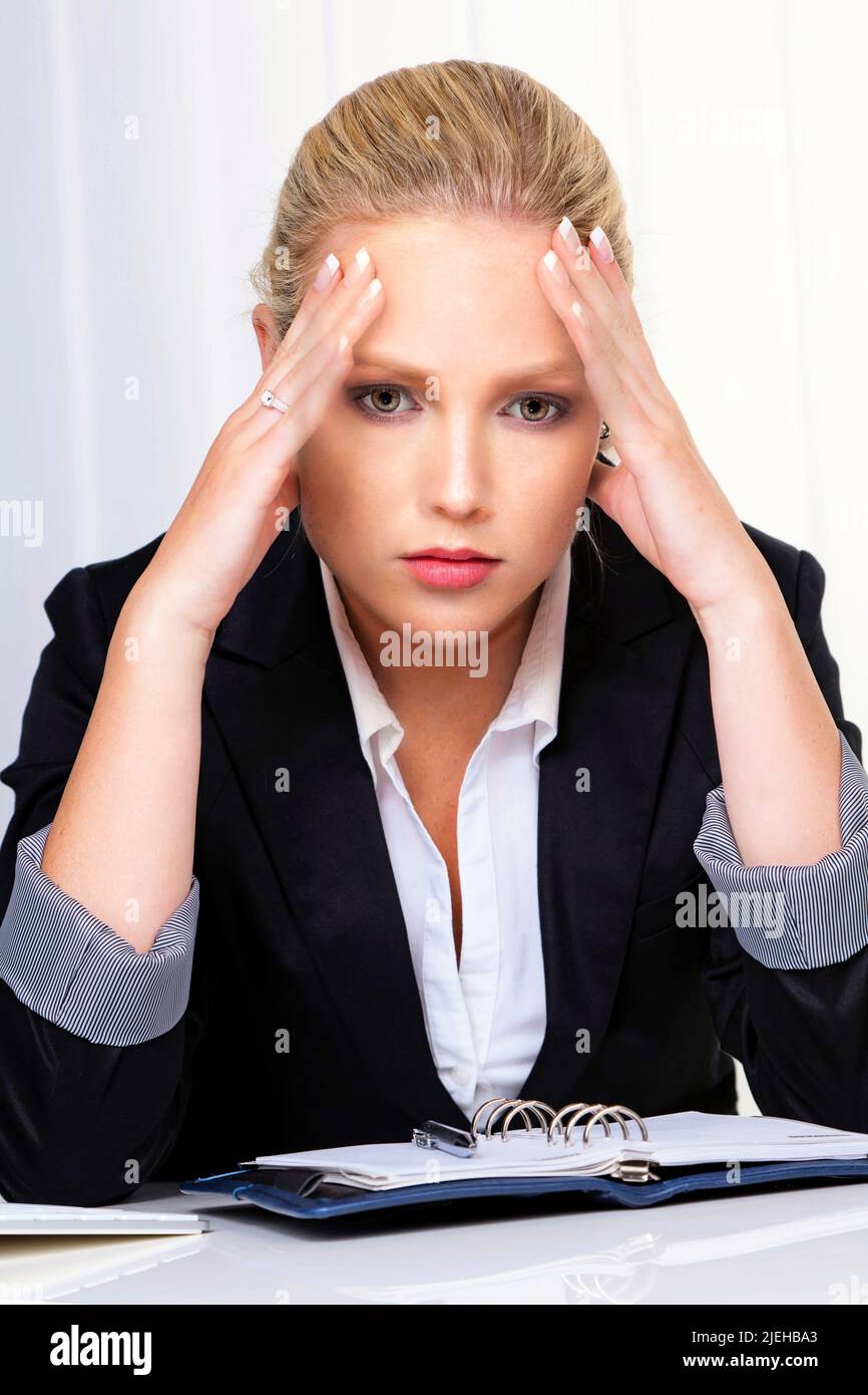 Eine junge Frau im Büro mit Migräne und Kopfschmerzen, Frau, 30, 35, Jahre, Biondo, biondo, Foto Stock
