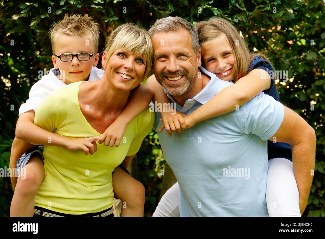 Eine glückliche Familie im Garten, 4 Personen, Mann, Frau, Sohn und Tochter, 45, 50, 4, 7, Jahre, Foto Stock