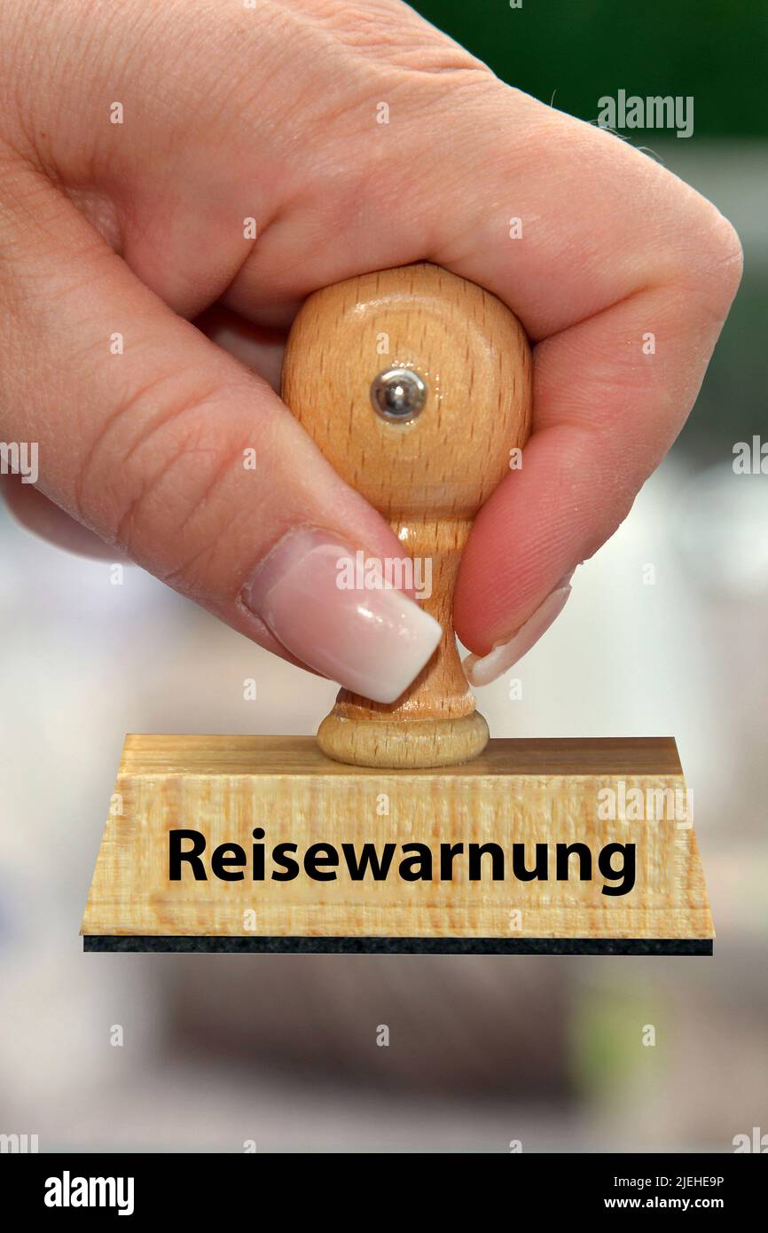 Hand mit Stempel, Frauenhand, Aufschrift: Reisewarnung, Foto Stock