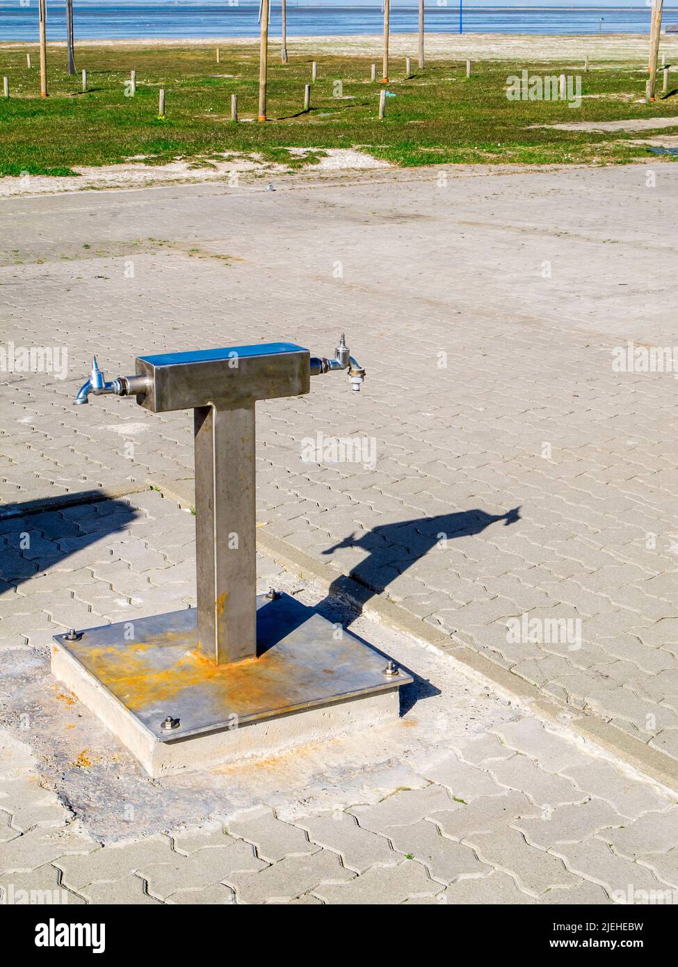 Vista di un'area di lavaggio per stivali di gomma dopo un'escursione mudflat con ombre calate sulla spiaggia tedesca del Mare del Nord nella Frisia orientale vicino a Neuharlingersiel. Foto Stock