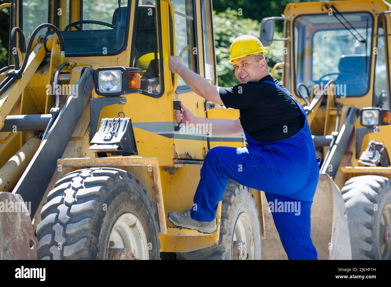 Bauarbeiter an einer Arbeitsmaschine, Bagger, Baggerfahrer mit Schutzhelm, Mann, 35, 40, Jahre, Foto Stock