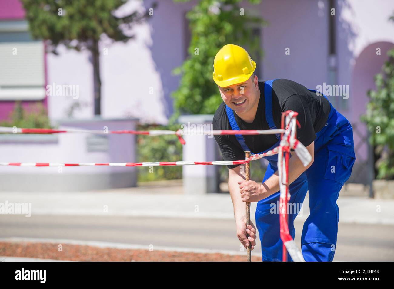 Ein Arbeiter überprüft die Baustellenabsperrung , Mann, 35, 40, Jahre, gelber Schutzhelm, Foto Stock