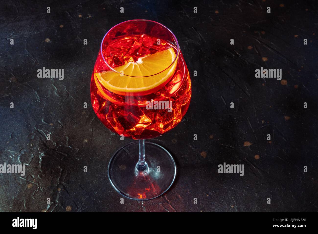 Cocktail Aperol con una fetta di arancia fresca, bevanda fredda estiva italiana su sfondo di ardesia nera con spazio copia Foto Stock