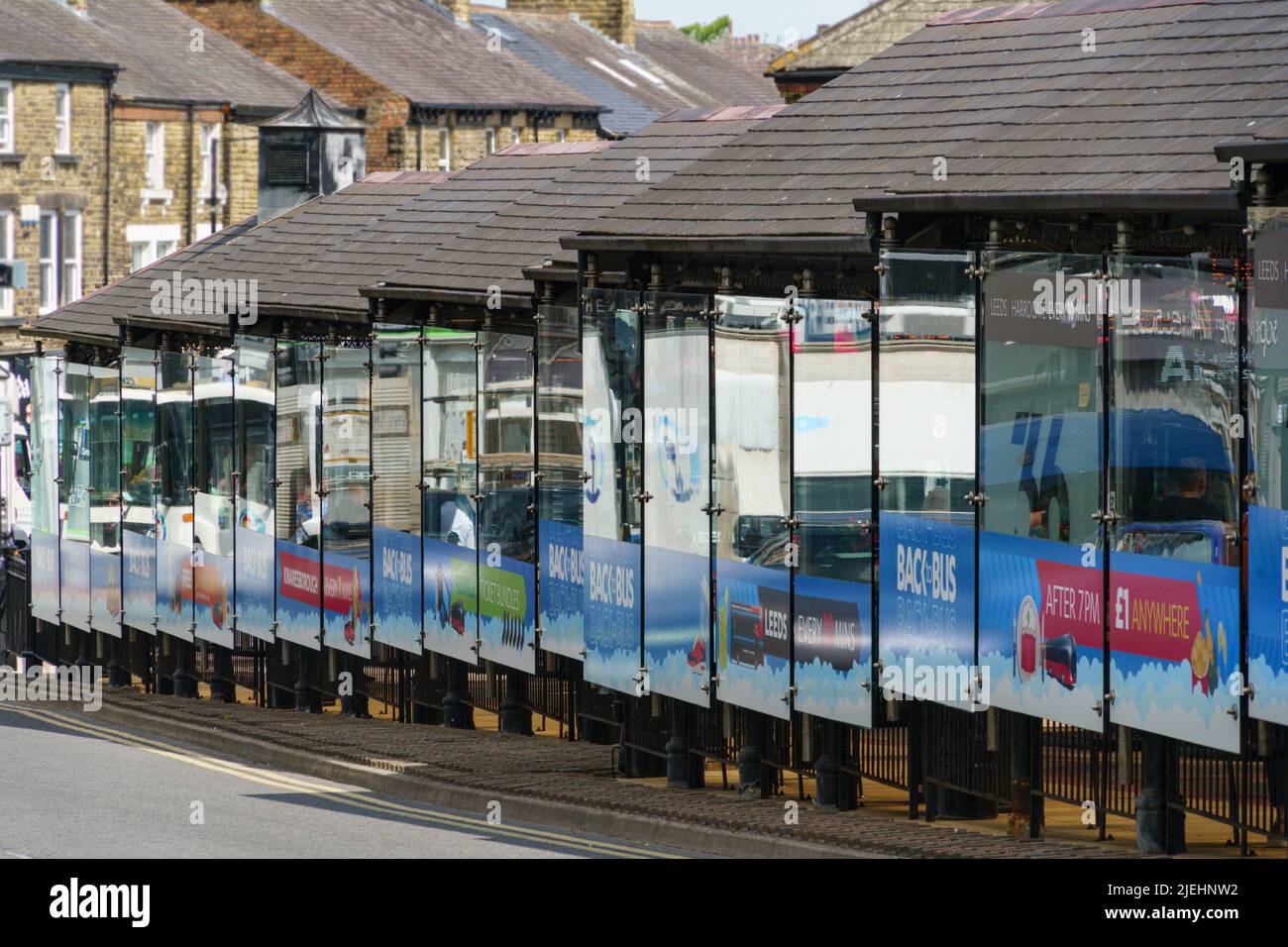 Un lungo rifugio per autobus vicino alla stazione degli autobus di Harrogate con pannelli di vetro riflettenti, Harrogate, North Yorkshire, Inghilterra, Regno Unito. Foto Stock