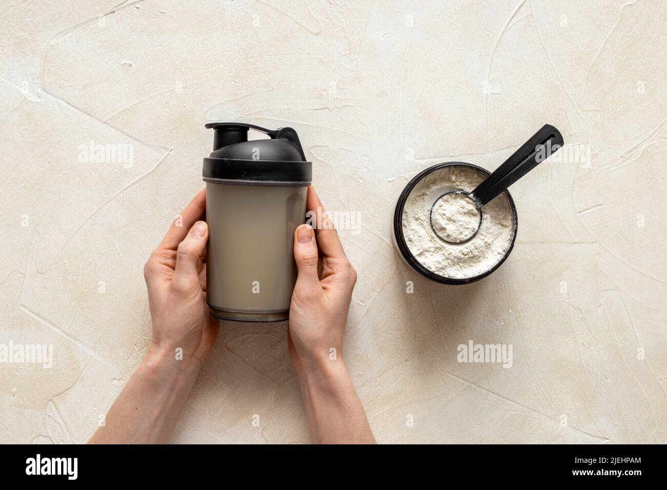 Flacone per agitatore sportivo in mani e proteine del siero di latte in vaso. Fitness e dieta palestra nutrizione Foto Stock