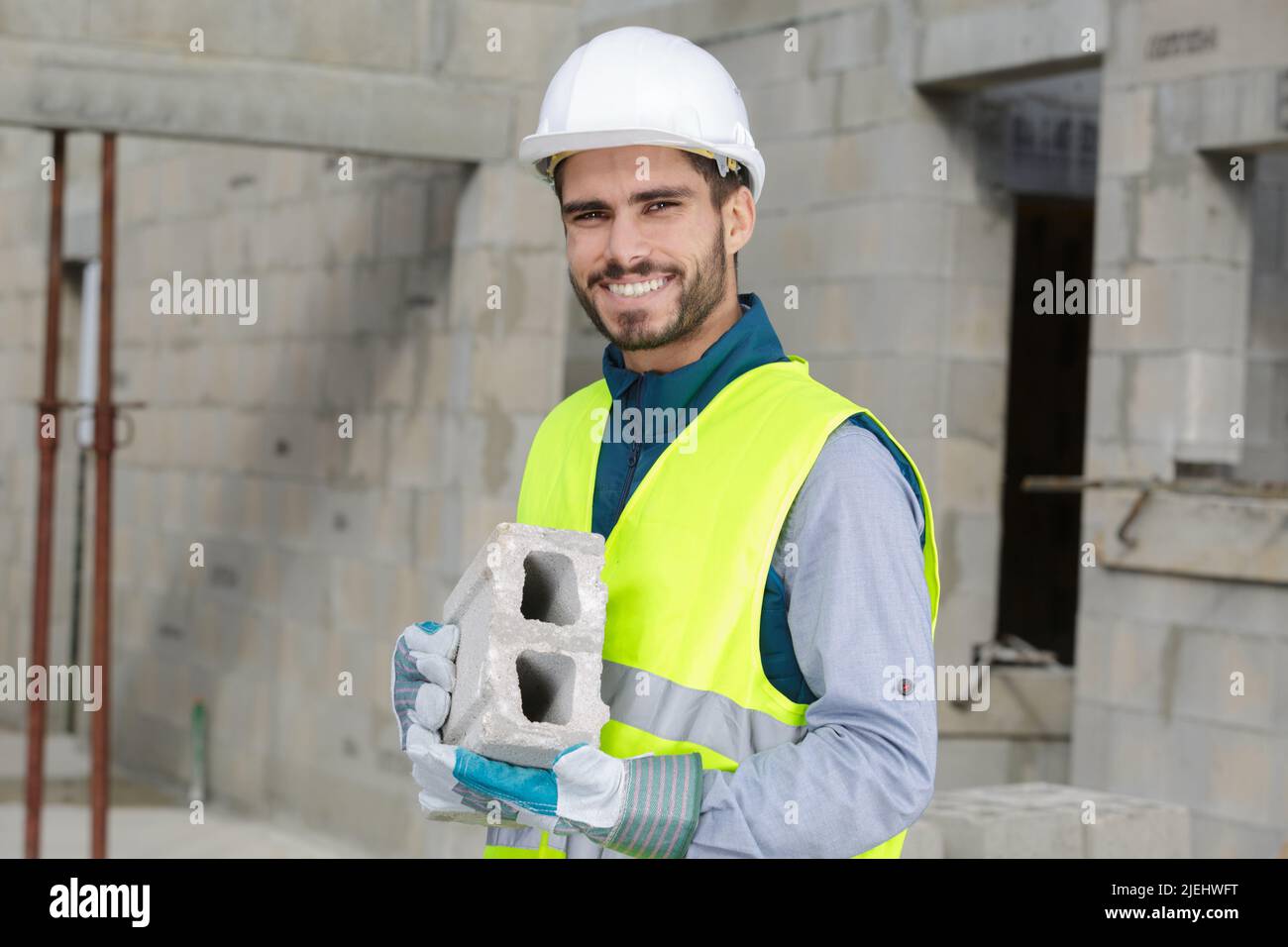 uomo costruttore che lavora con blocco di cemento Foto Stock