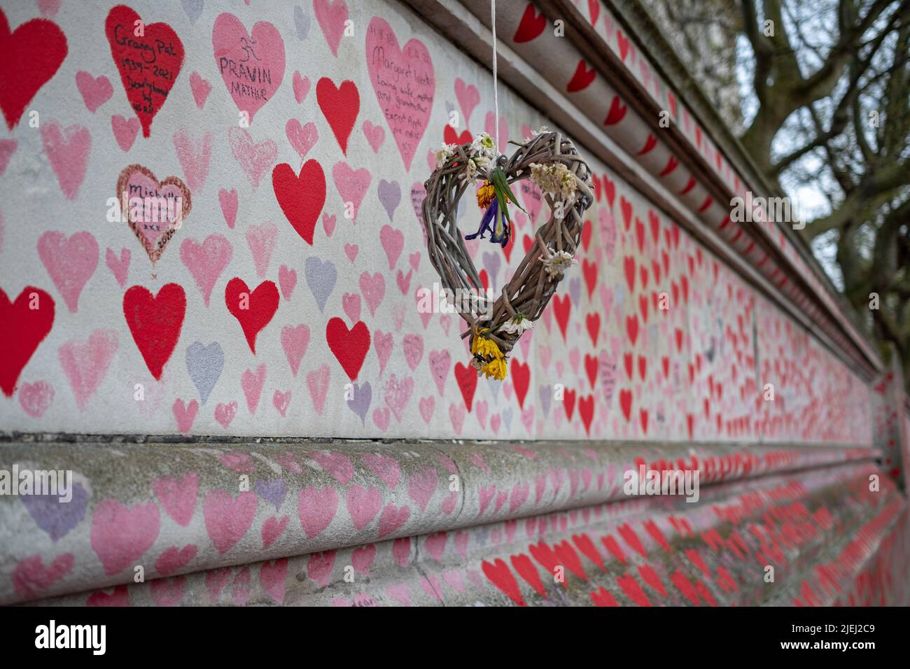 La cinta muraria nazionale di Londra con un cuore di legno intessuto che commemora una delle vittime della pandemia. South Bank, Londra, Regno Unito. Foto Stock