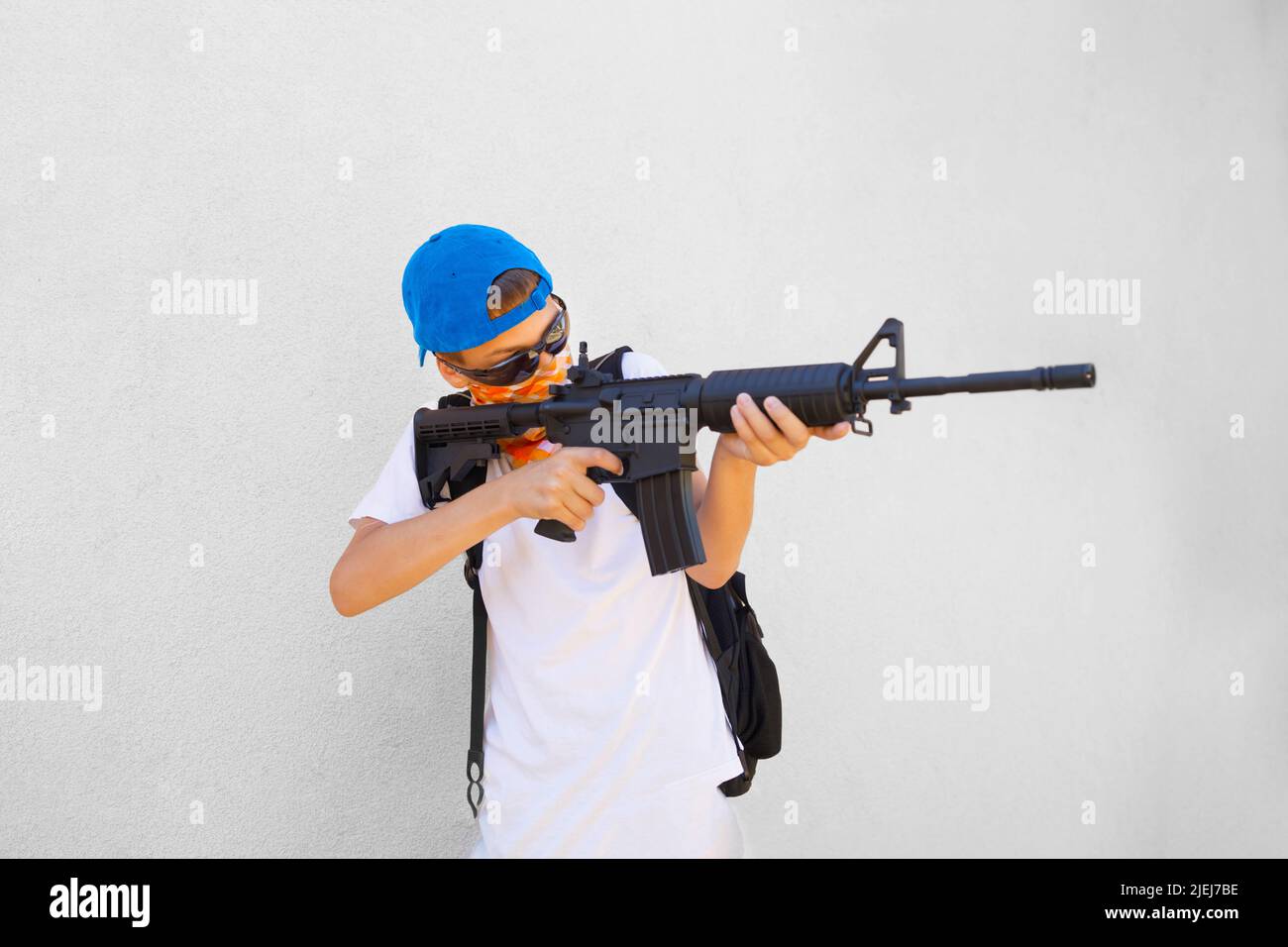 Ritratto di un adolescente aggressivo che punta un fucile. Concetto raffigurante il problema delle tirature scolastiche. Foto Stock