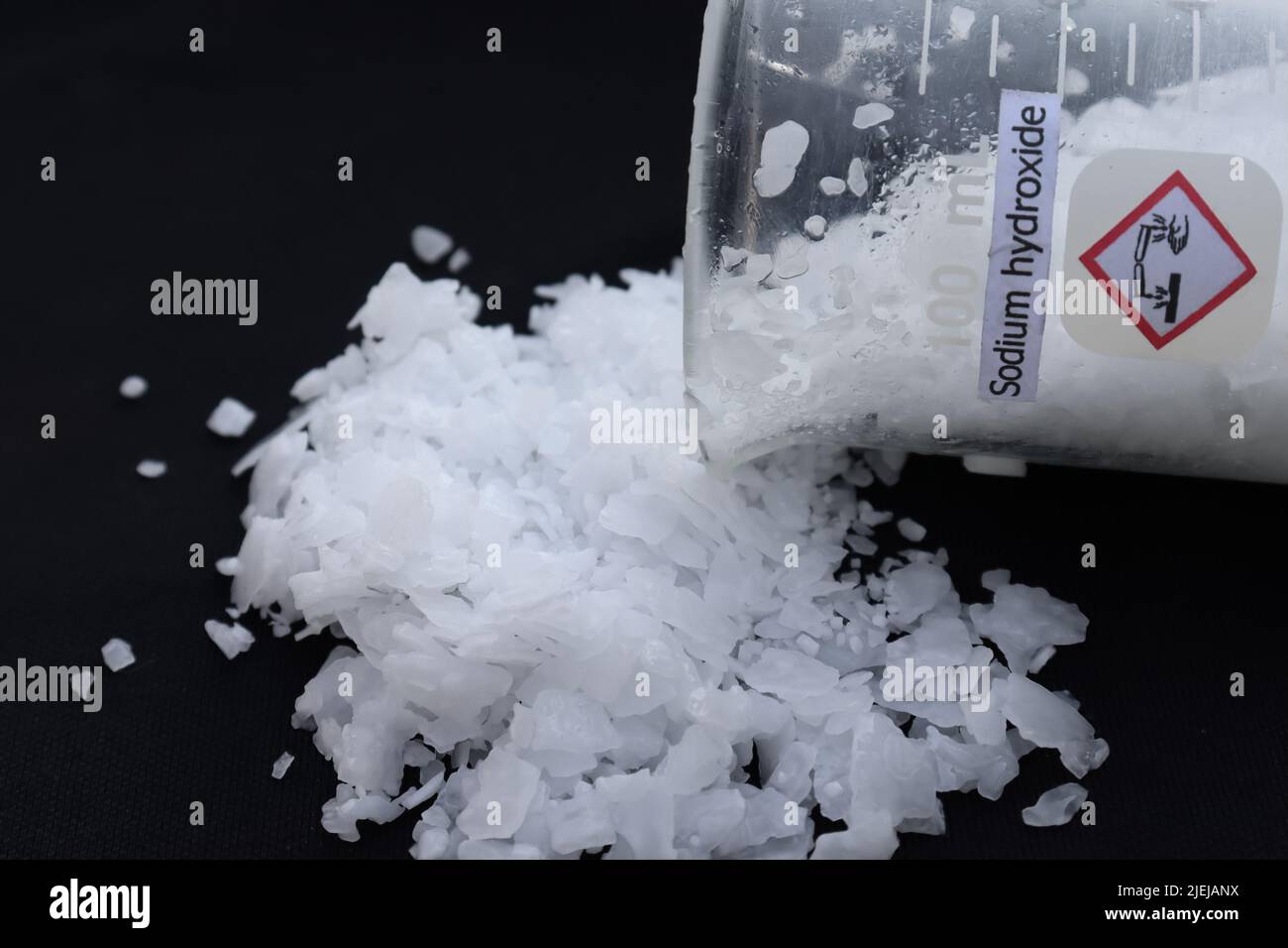 scaglie di soda caustica su sfondo nero Foto stock - Alamy