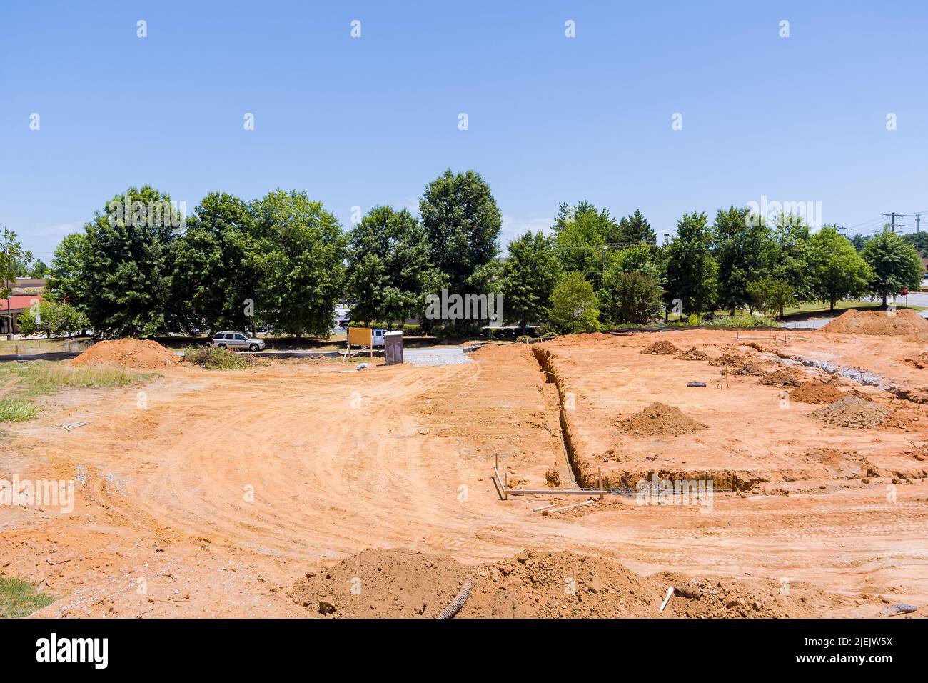 Vista di un cantiere con una trincea scavata sotto una fondazione in calcestruzzo Foto Stock