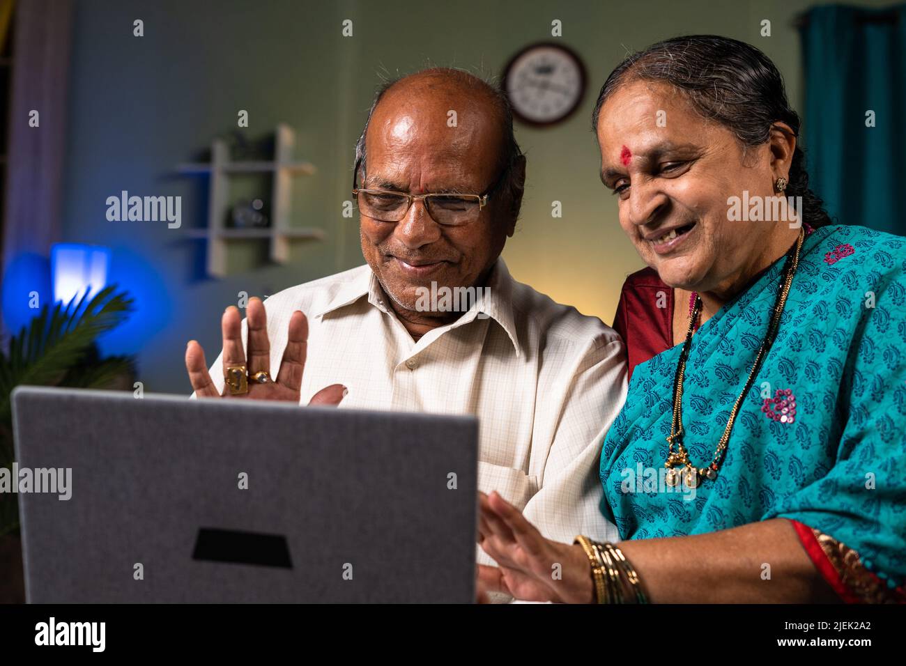 Coppia sorridente felice che fa videochiamata sul portatile a casa - concetto di tecnologia, rapporto e felicità Foto Stock