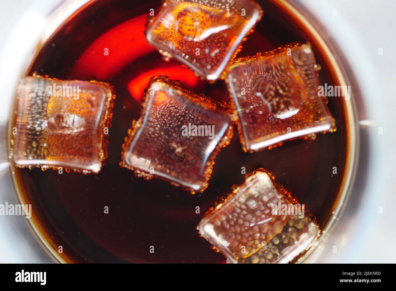 il ghiaccio gocciolando nel bicchiere delle bevande fredde Foto Stock