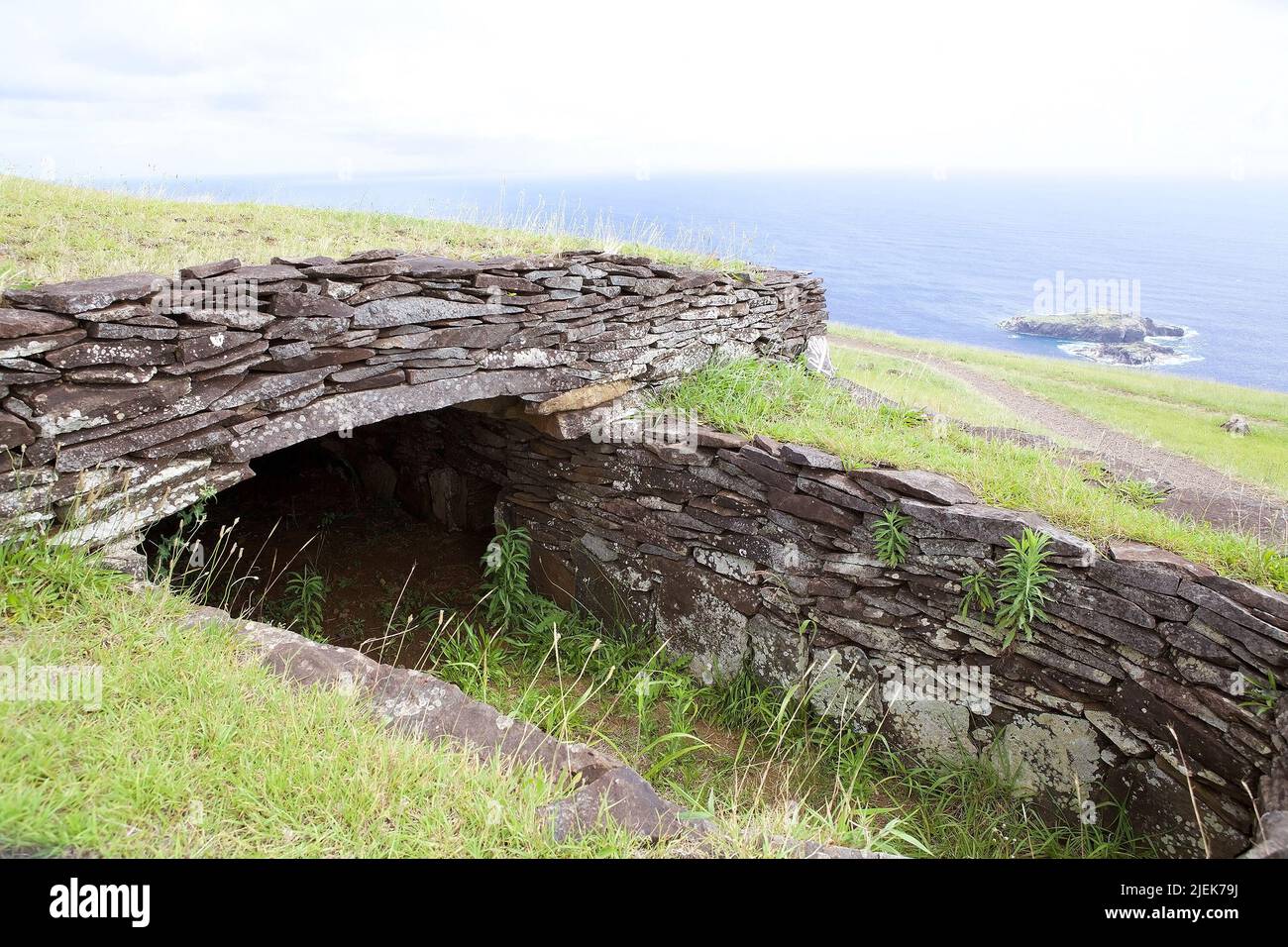 Case in pietra restaurate a Orongo sul vulcano Rano Kau sull'isola di Pasqua, Cile, con le isole sullo sfondo. Orongo era un centro cerimoniale, p. Foto Stock