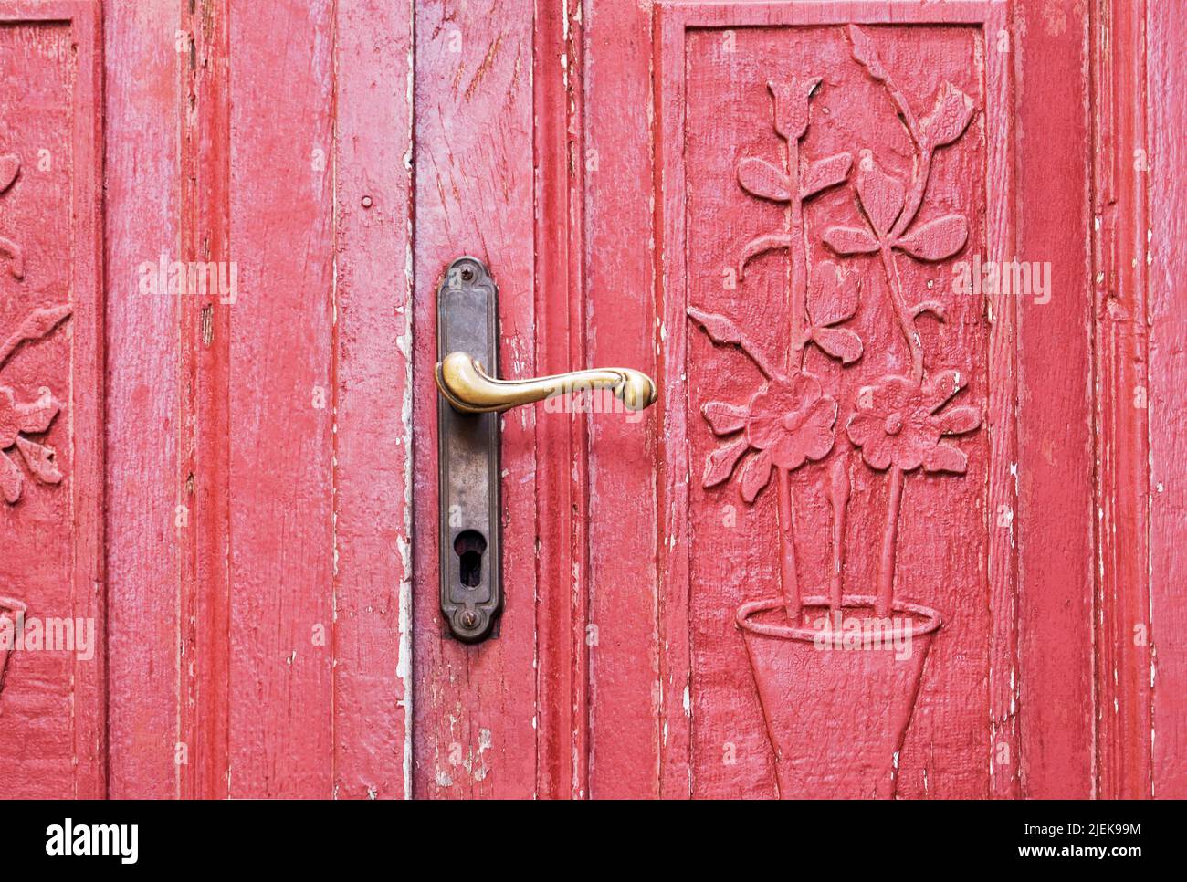 una vecchia porta rossa con intagli ornamentali Foto Stock