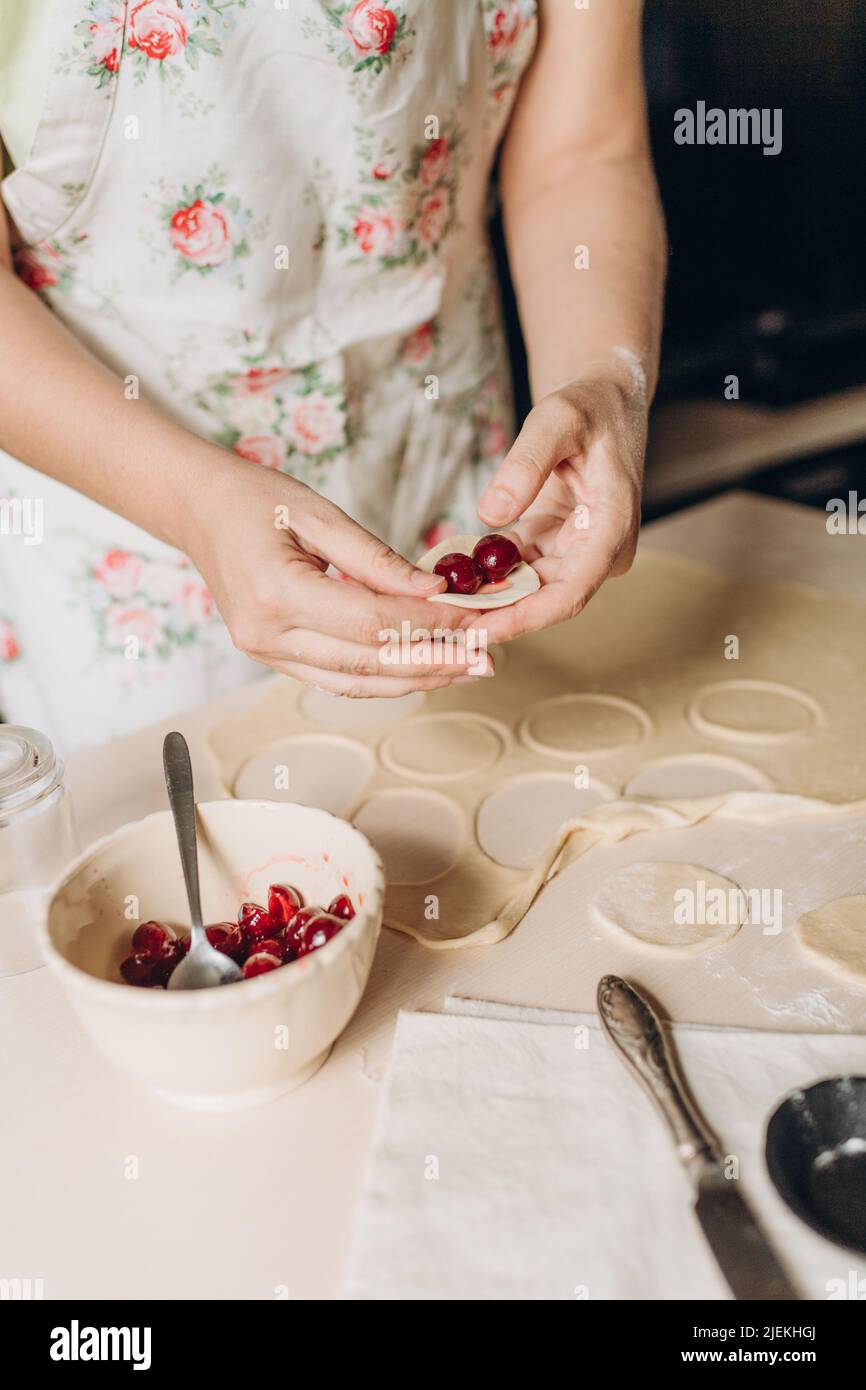 il processo di preparazione della pasta in cucina a casa, la cucina a casa, le mani femminili preparare il cibo Foto Stock