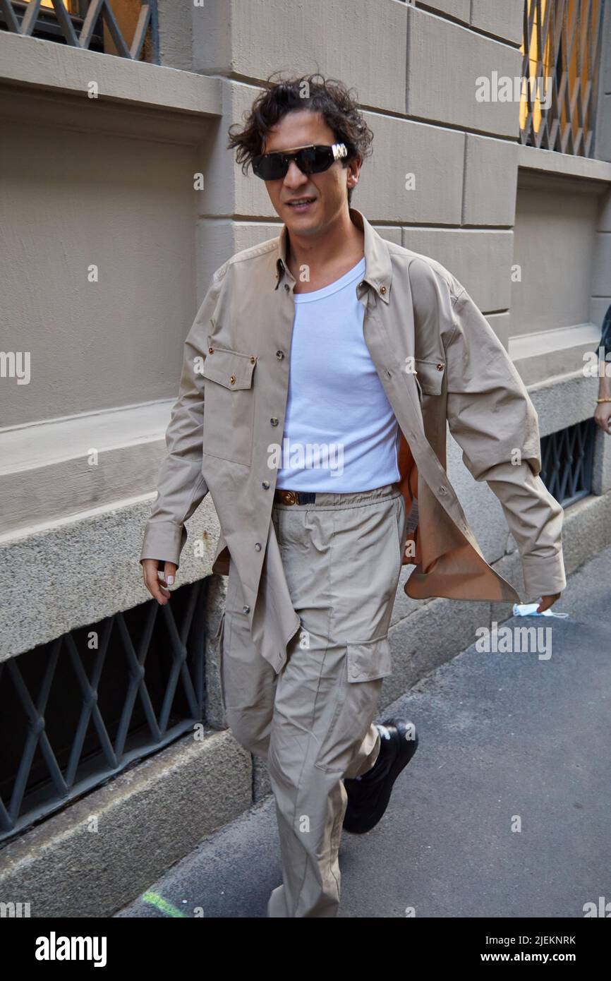 MILANO, ITALIA - 18 GIUGNO 2022: Uomo con giacca e pantaloni beige prima della sfilata di moda Versace, Milano Fashion Week Street Style Foto Stock