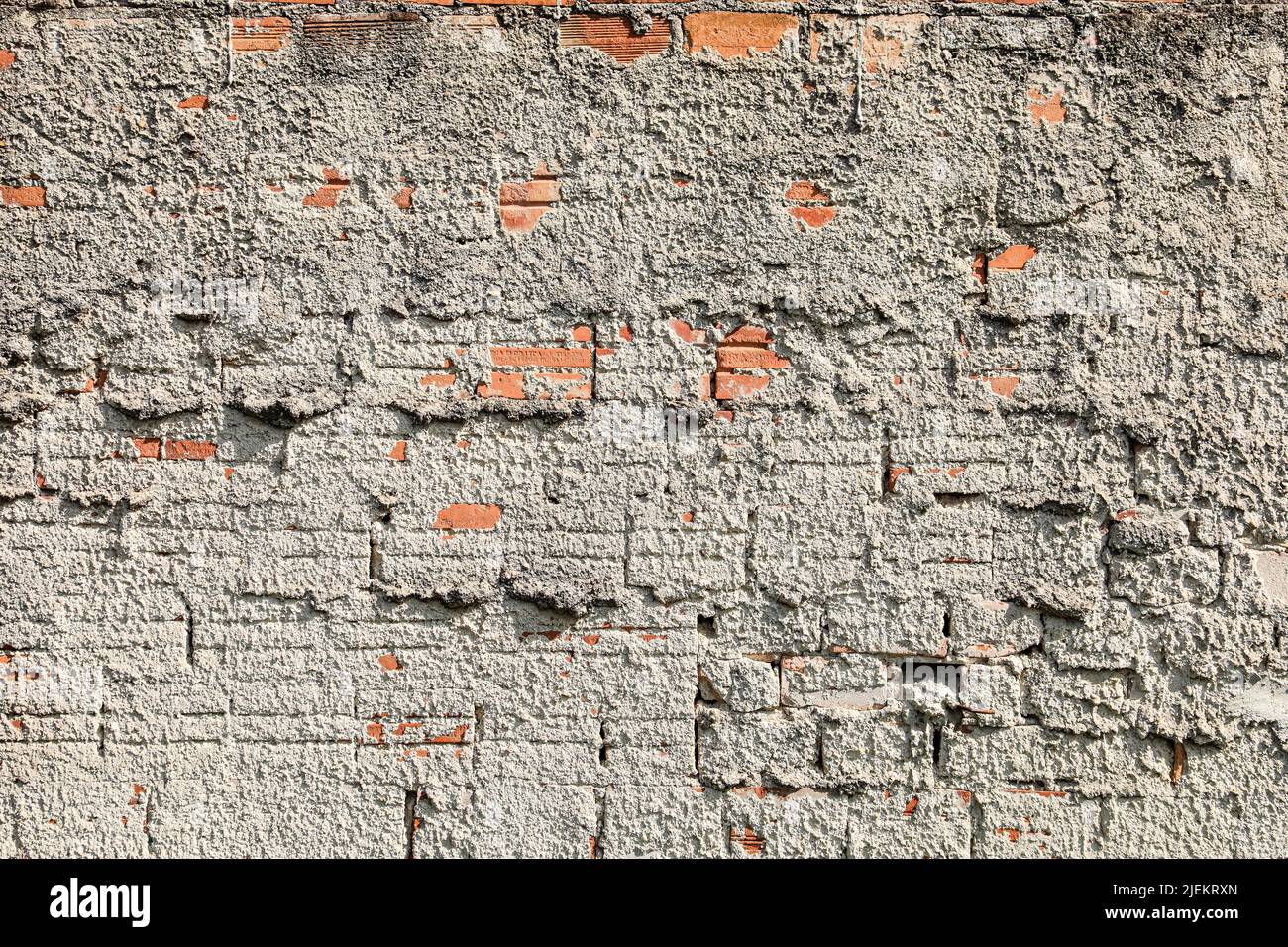 Muro muto con intonaco e alcuni mattoni esposti, con segni di tempo, evidenziando la sua texture. Foto Stock