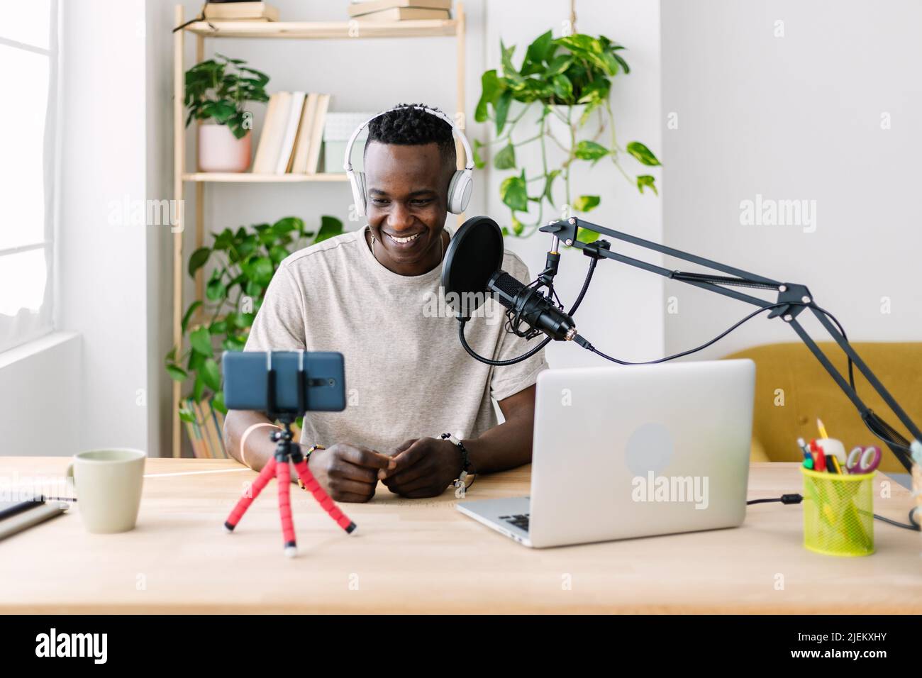 Giovane adulto africano uomo in streaming video dal vivo in casa studio Foto Stock