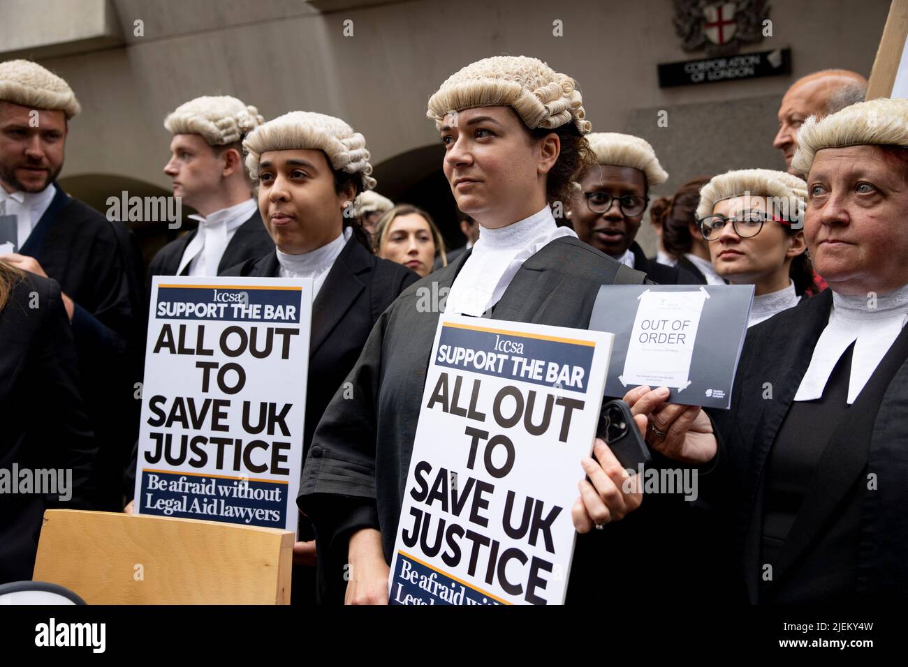 Londra, Regno Unito. 27th giugno 2022. Un gruppo di barristi criminali tiene cartelloni fuori dal Bailey vecchio. I barristi criminali scoppano dai tribunali in sciopero intorno al Regno Unito per disputa in pay. La Criminal Bar Association (CBA) ha dichiarato che i redditi per i barristi criminali junior sono scesi del 30% negli ultimi 20 anni e che hanno raggiunto un reddito medio dopo le spese di £12200 nei primi 3 anni di pratica. Essi richiedono un aumento del 25% della tassa di assistenza legale, che è superiore al 15% minimo raccomandato dalla revisione penale di assistenza legale pubblicata lo scorso dicembre. Credit: SOPA Images Limited/Alamy Live News Foto Stock