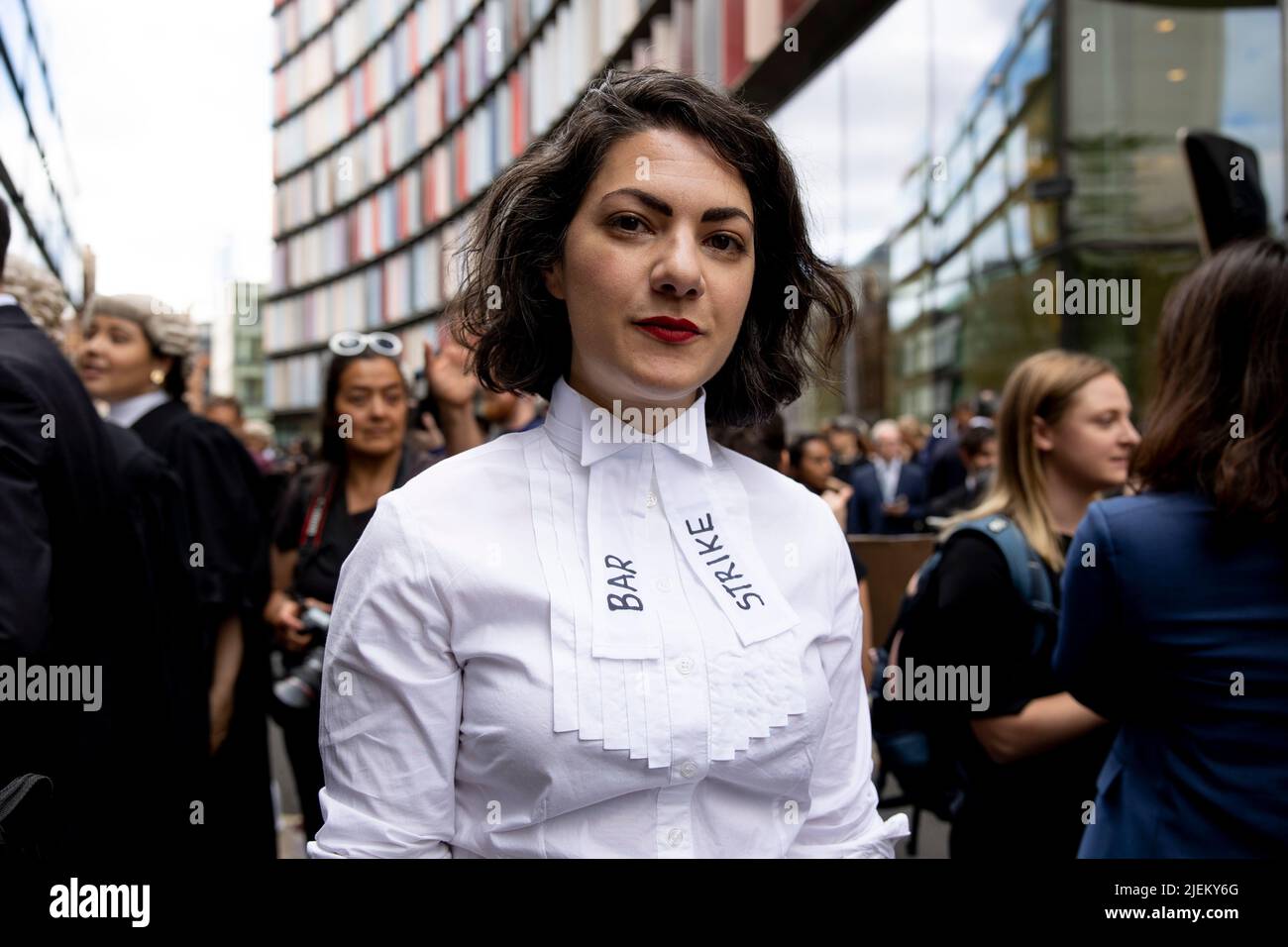 Un barrister criminale junior è visto a Old Bailey con 'Bar Strike' sulla sua uniforme di corte. I barristi criminali scoppano dai tribunali in sciopero intorno al Regno Unito per disputa in pay. La Criminal Bar Association (CBA) ha dichiarato che i redditi per i barristi criminali junior sono scesi del 30% negli ultimi 20 anni e che hanno raggiunto un reddito medio dopo le spese di £12200 nei primi 3 anni di pratica. Essi richiedono un aumento del 25% della tassa di assistenza legale, che è superiore al 15% minimo raccomandato dalla revisione penale di assistenza legale pubblicata lo scorso dicembre. Foto Stock