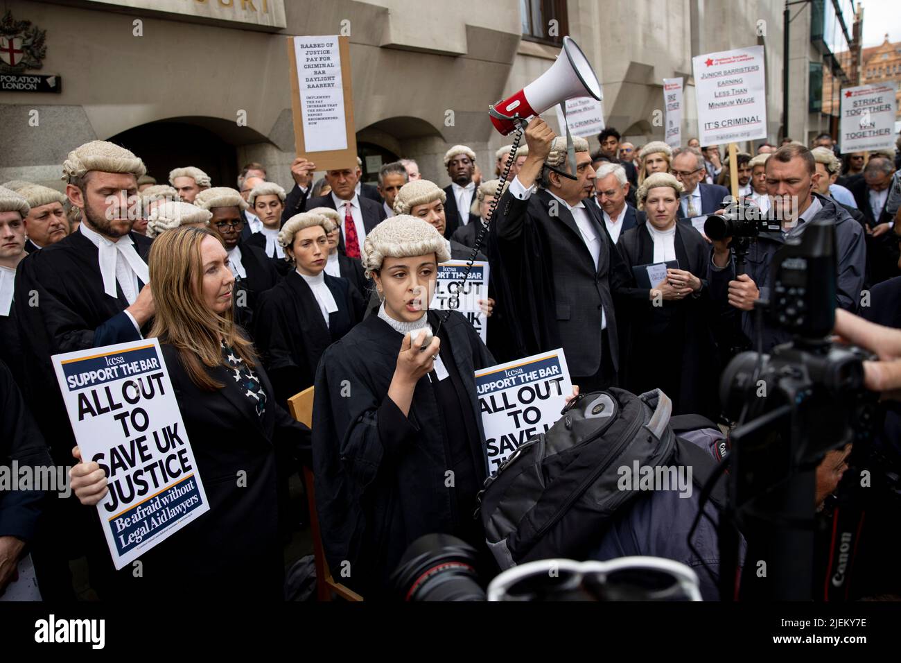 Un barrister junior sta dando un discorso al di fuori di Old Bailey durante l'azione di sciopero a Londra. I barristi criminali scoppano dai tribunali in sciopero intorno al Regno Unito per disputa in pay. La Criminal Bar Association (CBA) ha dichiarato che i redditi per i barristi criminali junior sono scesi del 30% negli ultimi 20 anni e che hanno raggiunto un reddito medio dopo le spese di £12200 nei primi 3 anni di pratica. Essi richiedono un aumento del 25% della tassa di assistenza legale, che è superiore al 15% minimo raccomandato dalla revisione penale di assistenza legale pubblicata lo scorso dicembre. Foto Stock