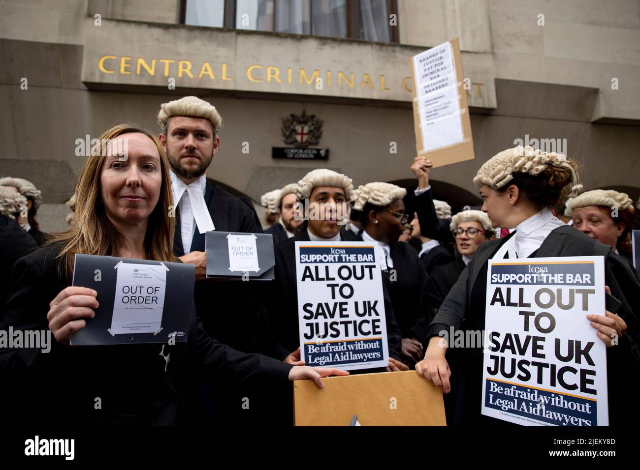 Londra, Regno Unito. 27th giugno 2022. Un gruppo di barrister criminali junior ha segni fuori del Bailey vecchio. I barristi criminali scoppano dai tribunali in sciopero intorno al Regno Unito per disputa in pay. La Criminal Bar Association (CBA) ha dichiarato che i redditi per i barristi criminali junior sono scesi del 30% negli ultimi 20 anni e che hanno raggiunto un reddito medio dopo le spese di £12200 nei primi 3 anni di pratica. Essi richiedono un aumento del 25% della tassa di assistenza legale, che è superiore al 15% minimo raccomandato dalla revisione penale di assistenza legale pubblicata lo scorso dicembre. Credit: SOPA Images Limited/Alamy Live News Foto Stock