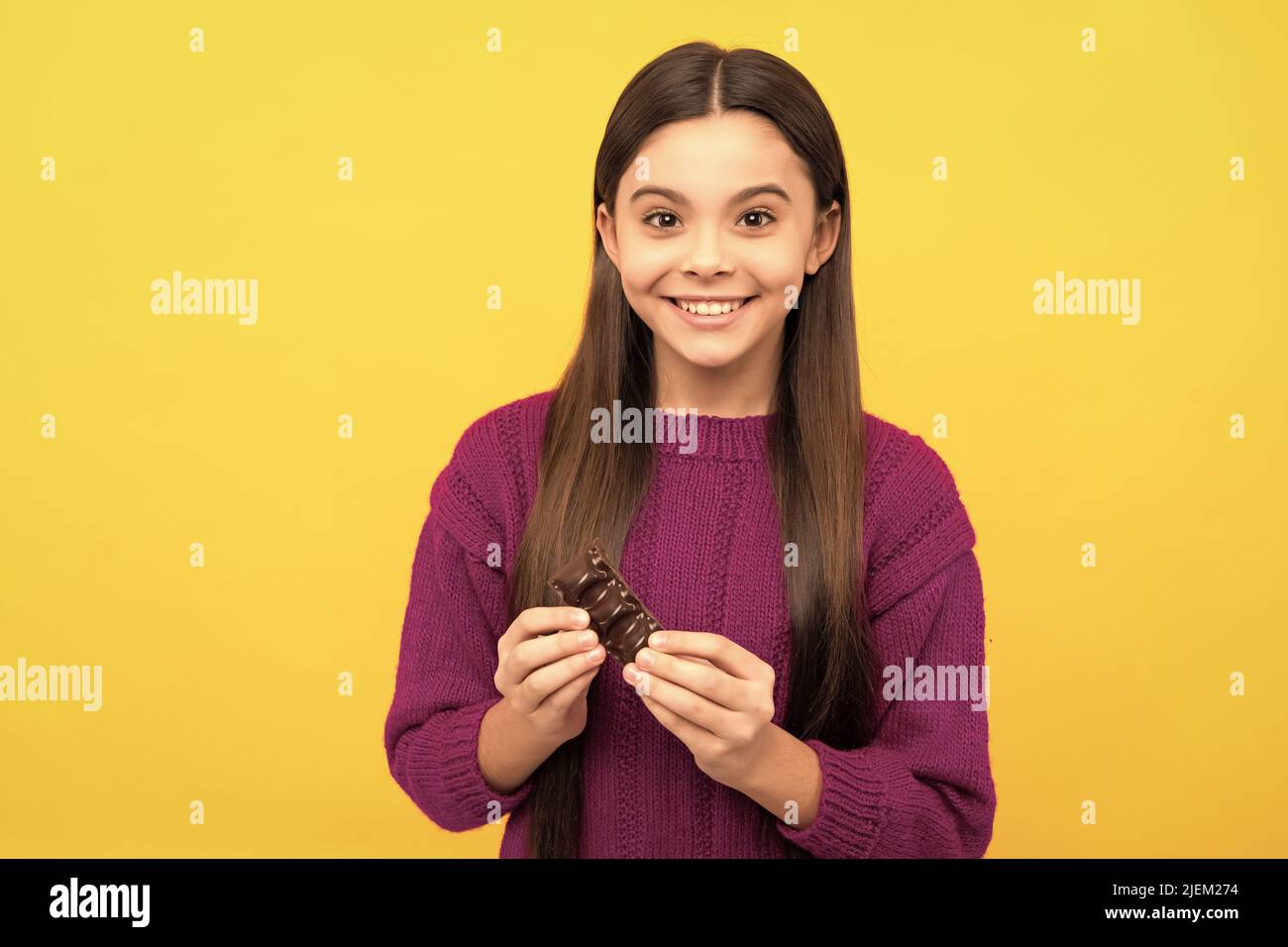 La sua dipendenza al cioccolato. Buon bambino cioccolato d'oro. Sorriso dolce-dente. Gustando uno spuntino dolce Foto Stock