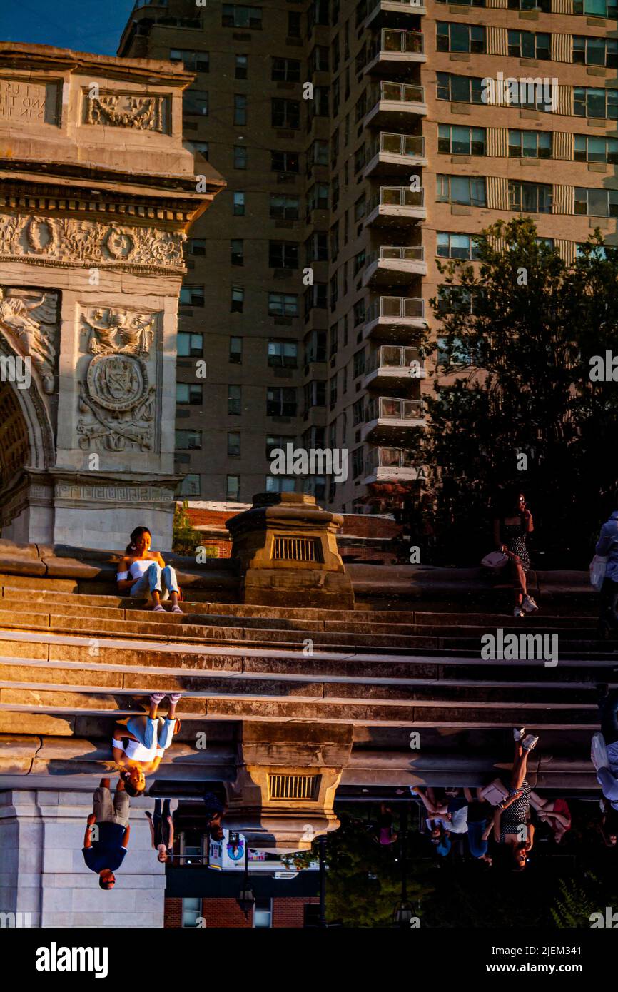 Un riflesso della donna nella fontana del Washington Square Park a New York City Foto Stock