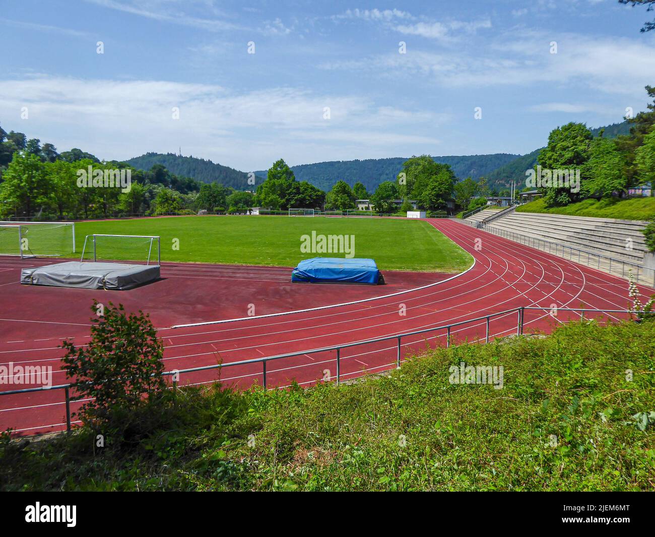 piccolo stadio comunale con campo d'erba, pista di atletica rossa e tribune nella germania meridionale Foto Stock