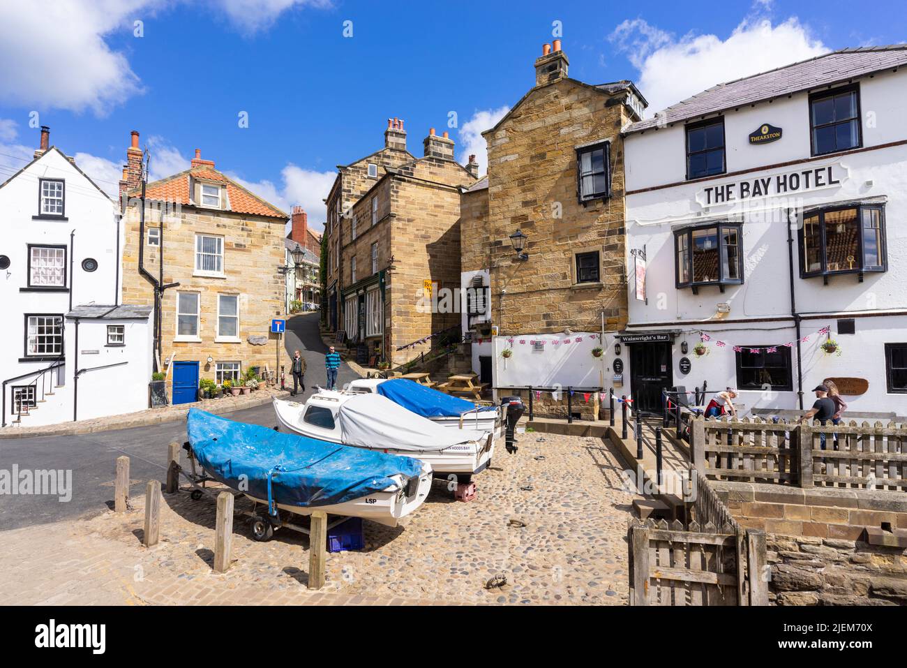 Robin Hood's Bay Yorkshire The Bay Hotel con barche da pesca di fronte al villaggio di Robin Hood's Bay Yorkshire North Yorkshire Inghilterra GB Europe Foto Stock