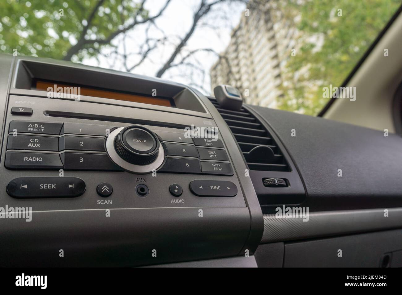 Primo piano dell'autoradio e della console del lettore CD con vista dall'esterno attraverso il parabrezza Foto Stock